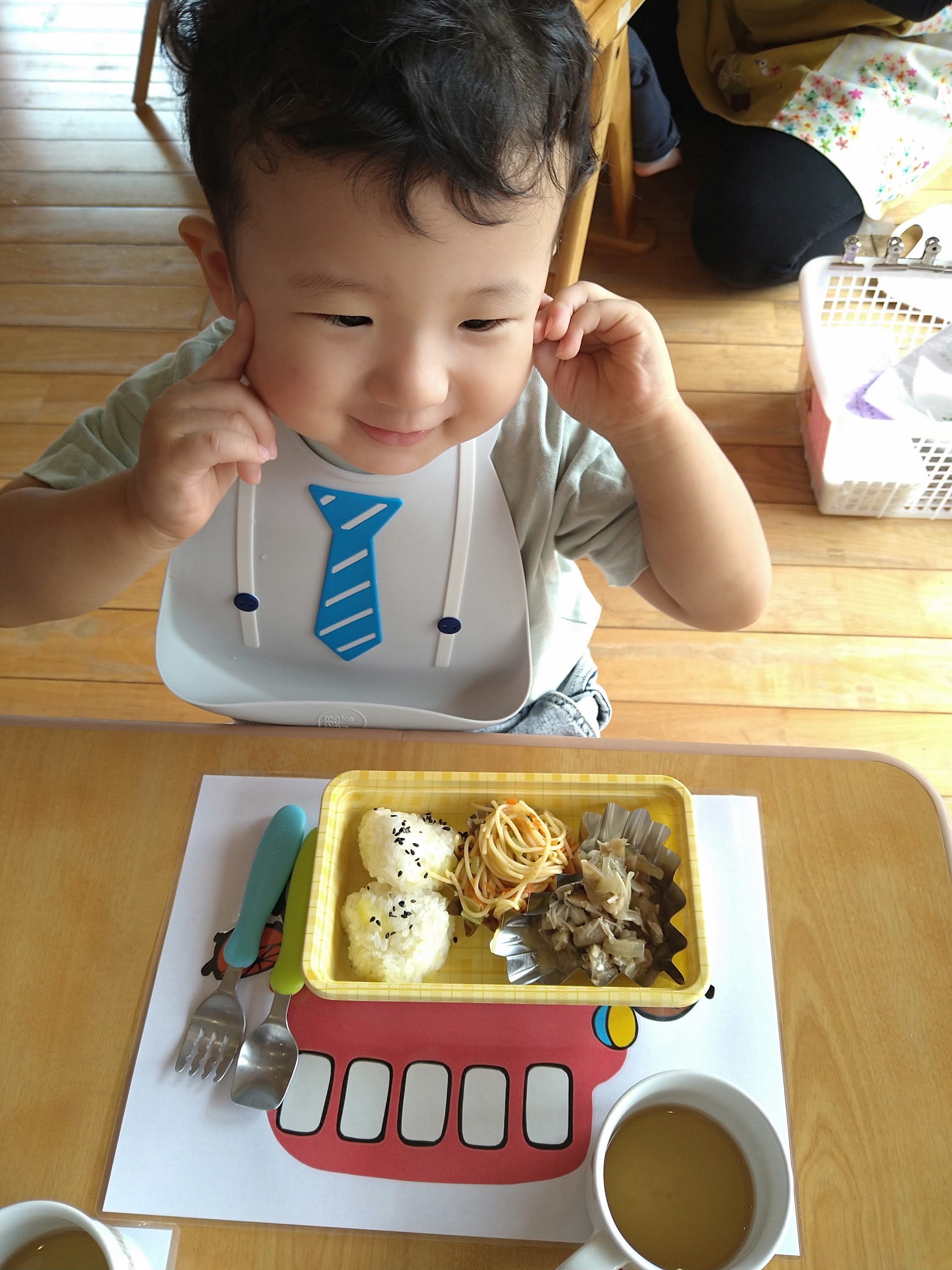 給食を前に笑顔を見せる子ども