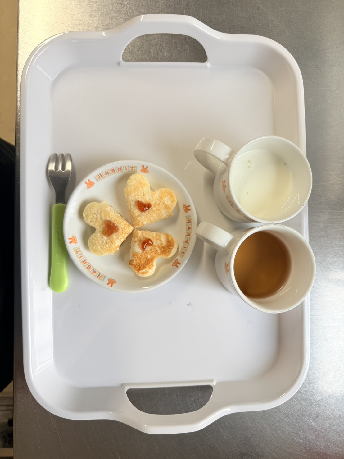 ハート形のおやつと飲み物を載せた給食トレー