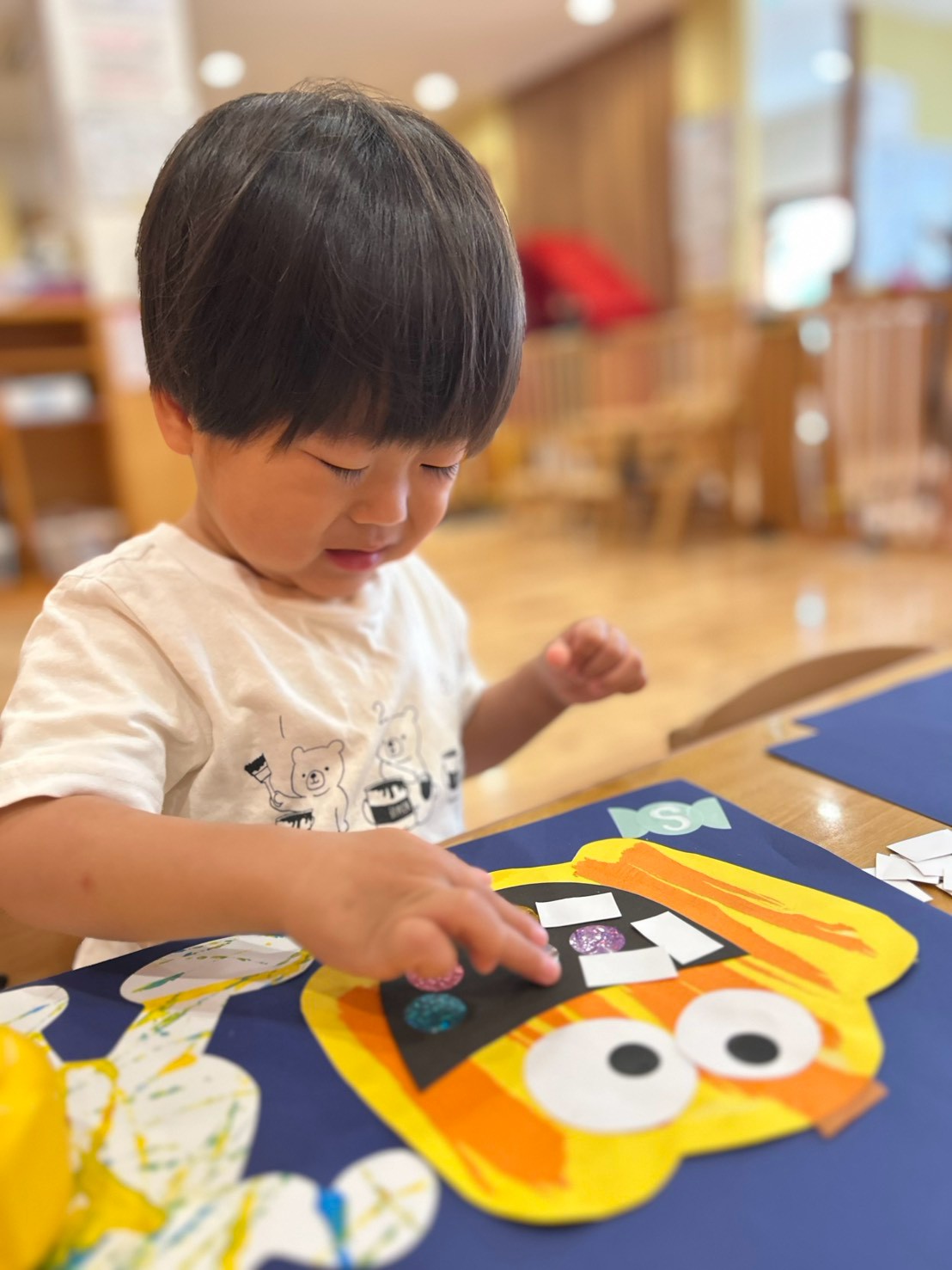 かぼちゃの口へ小さなパーツを貼る子ども
