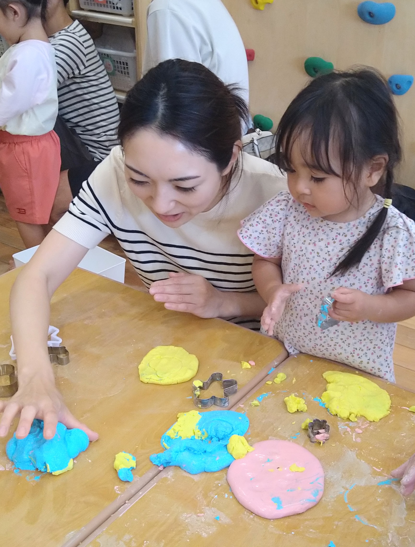 親子で色の異なるやわらかな素材に触れて遊ぶ様子