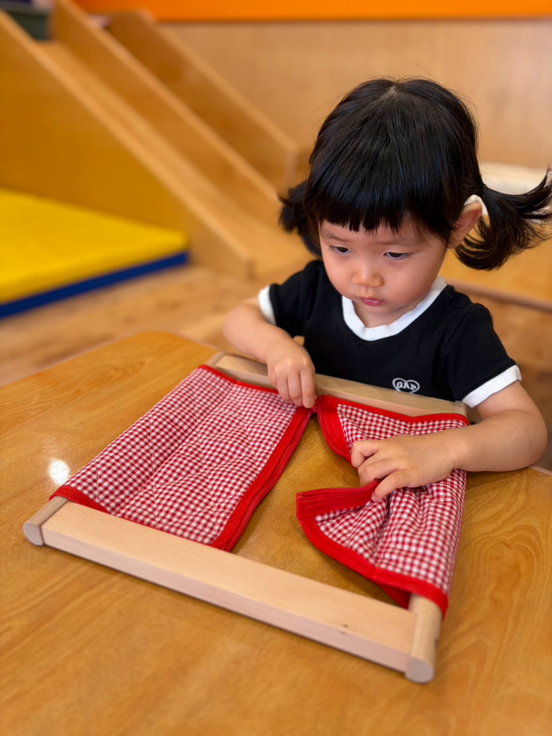 開いた着衣枠の布とチャックを確かめる子ども