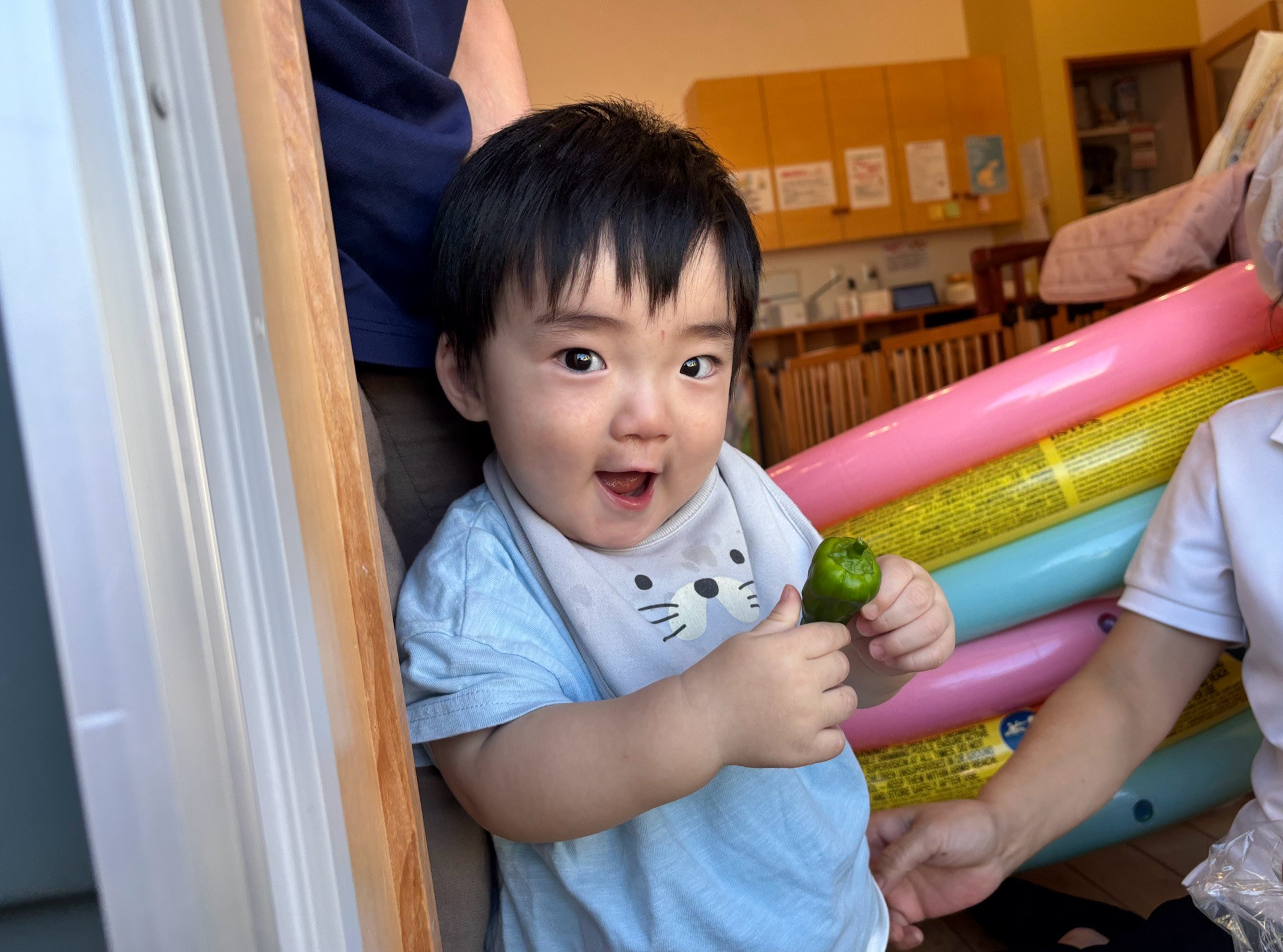 収穫したピーマンを両手で持って確かめる子ども
