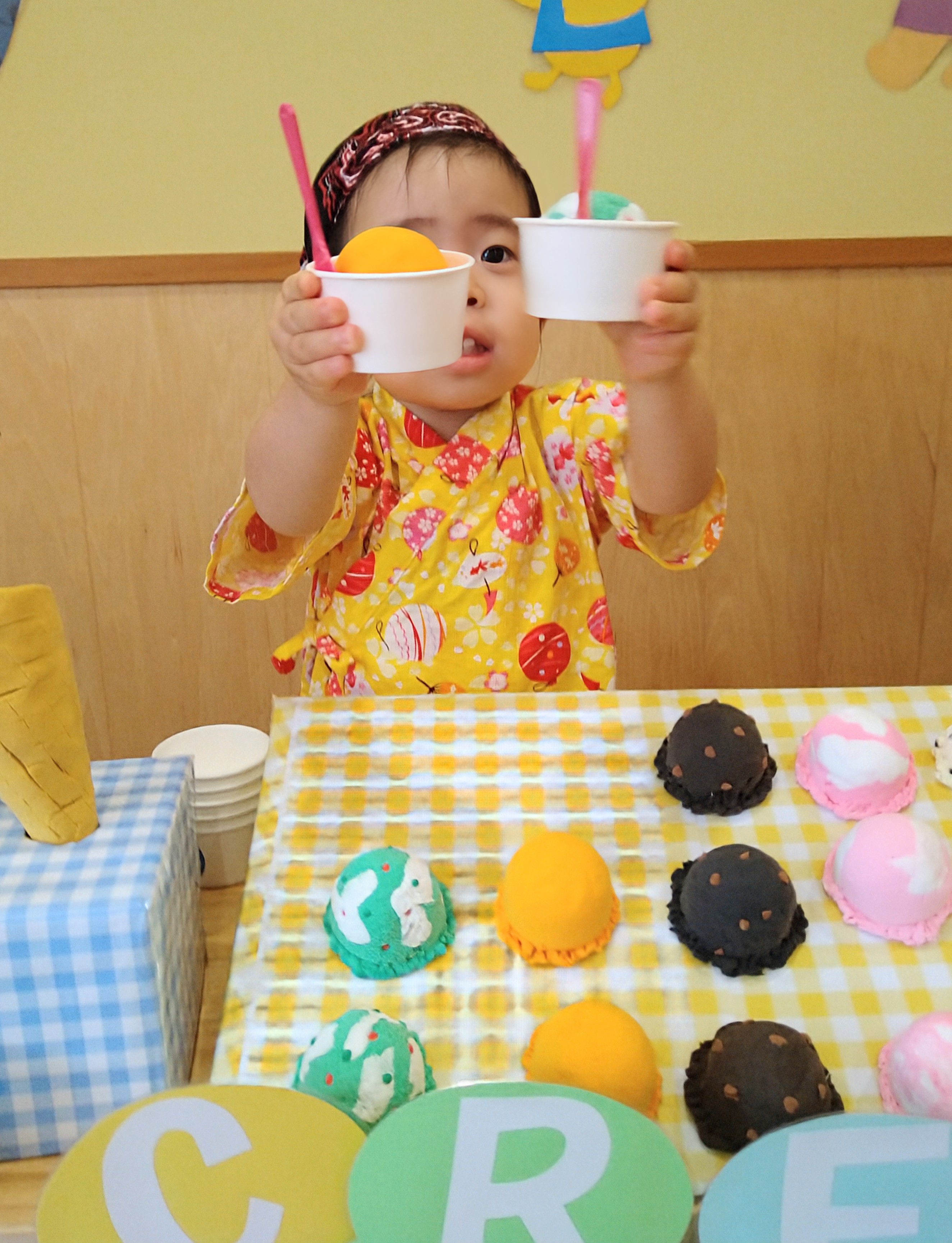 夏祭りのお店で二つのアイスを手に持って見せる様子
