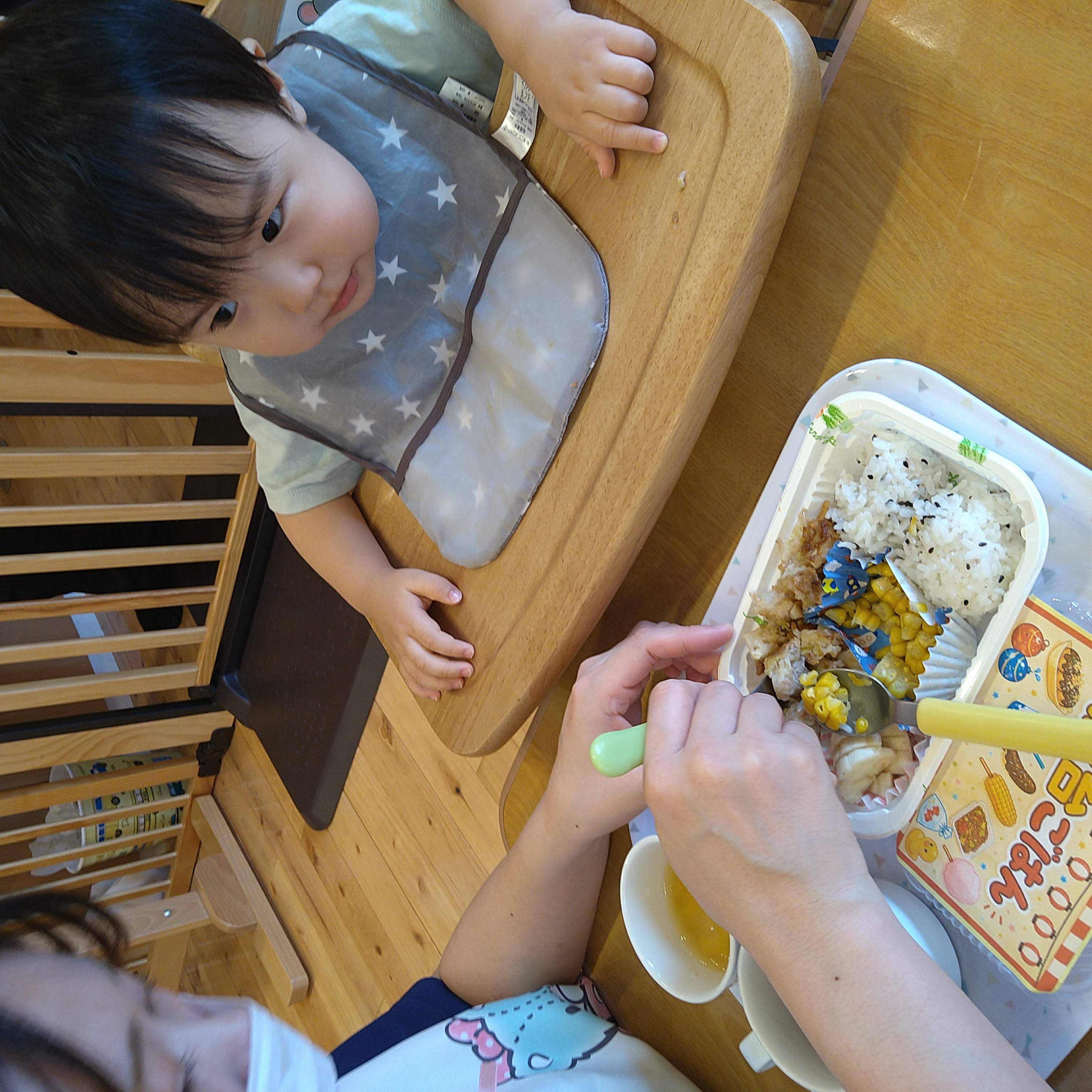 夏祭り給食を見つめながら自分で食べようとする子ども