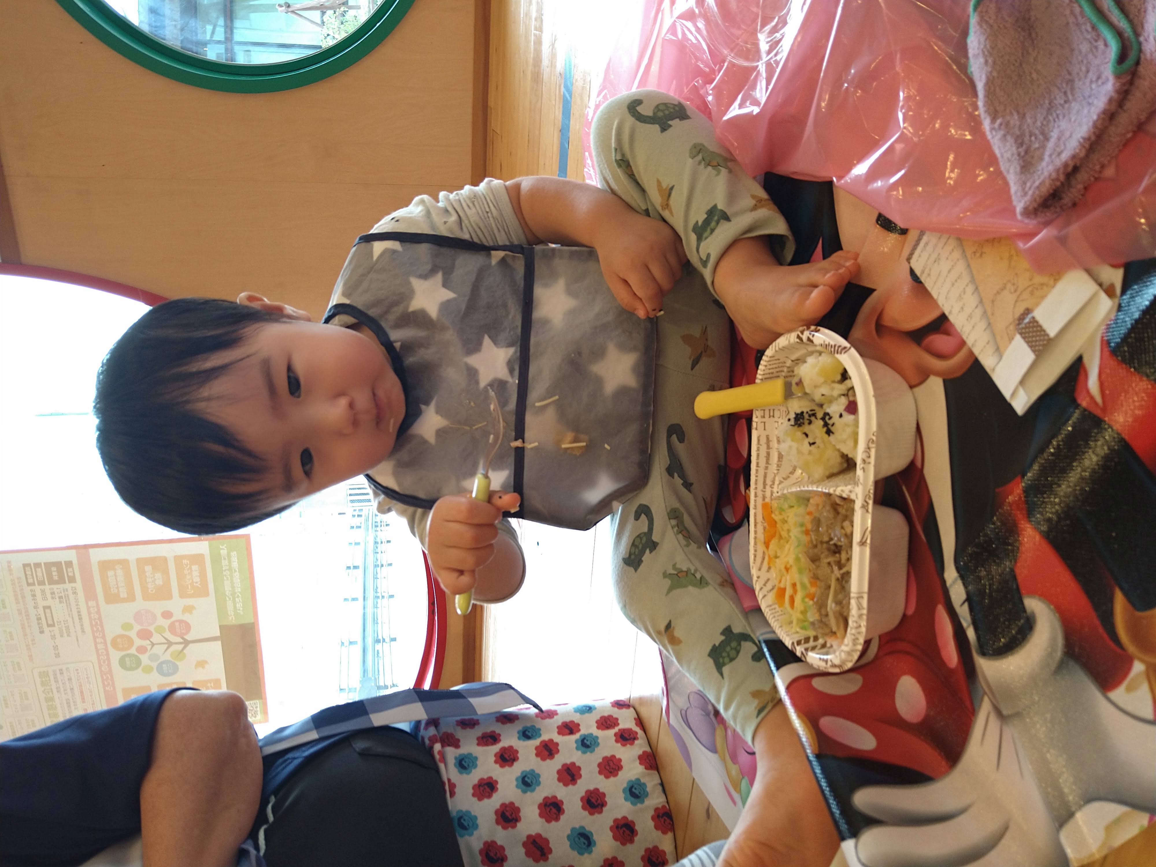 給食を見ながらスプーンを握って食べる子ども
