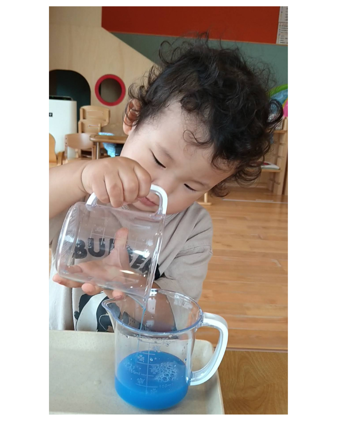 水の流れを見ながら容器の傾きを調整する子ども