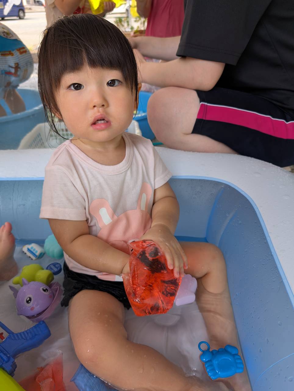 水の入った袋を両手で握り感触を確かめる子ども