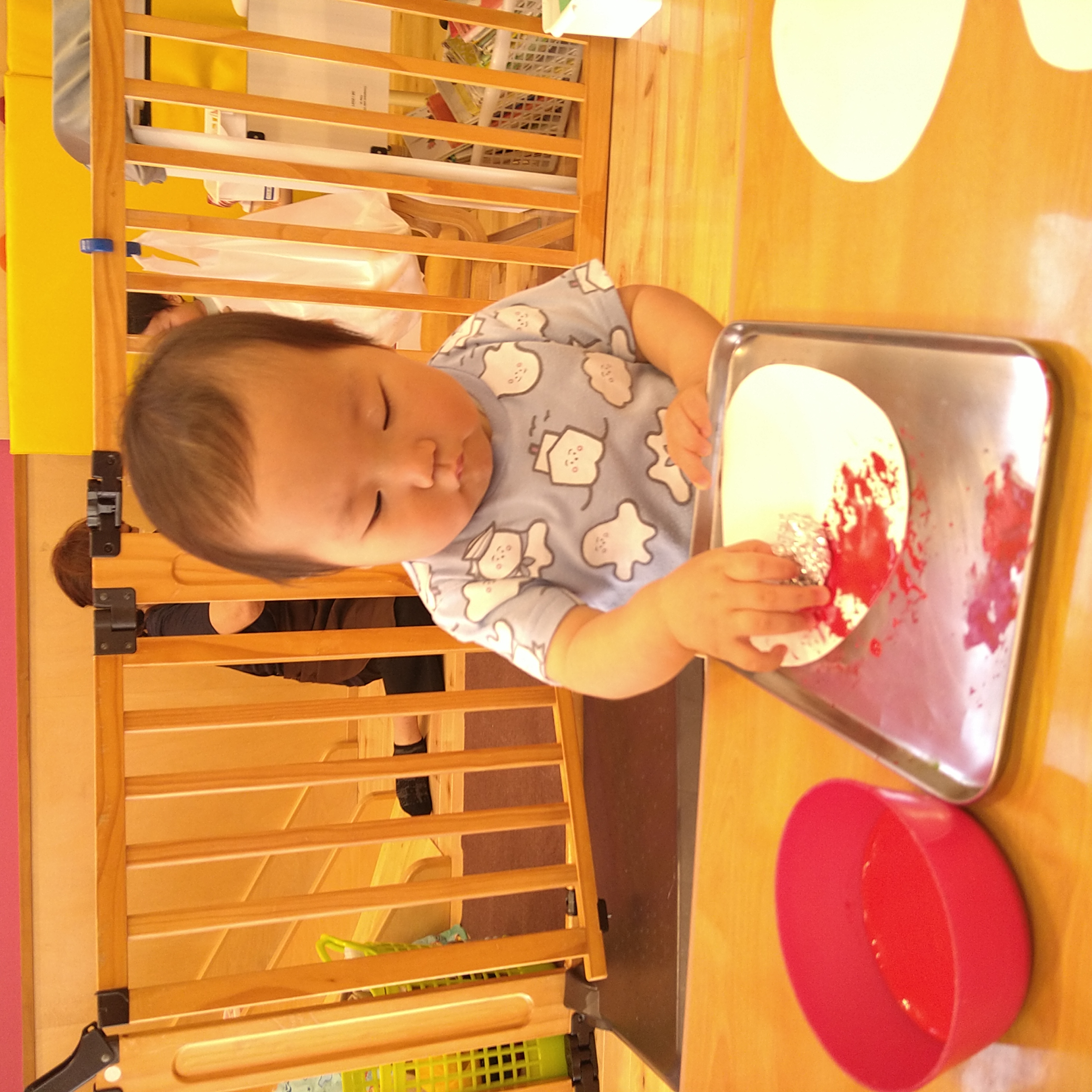 道具を紙へ押し当てて赤い色を付ける子ども