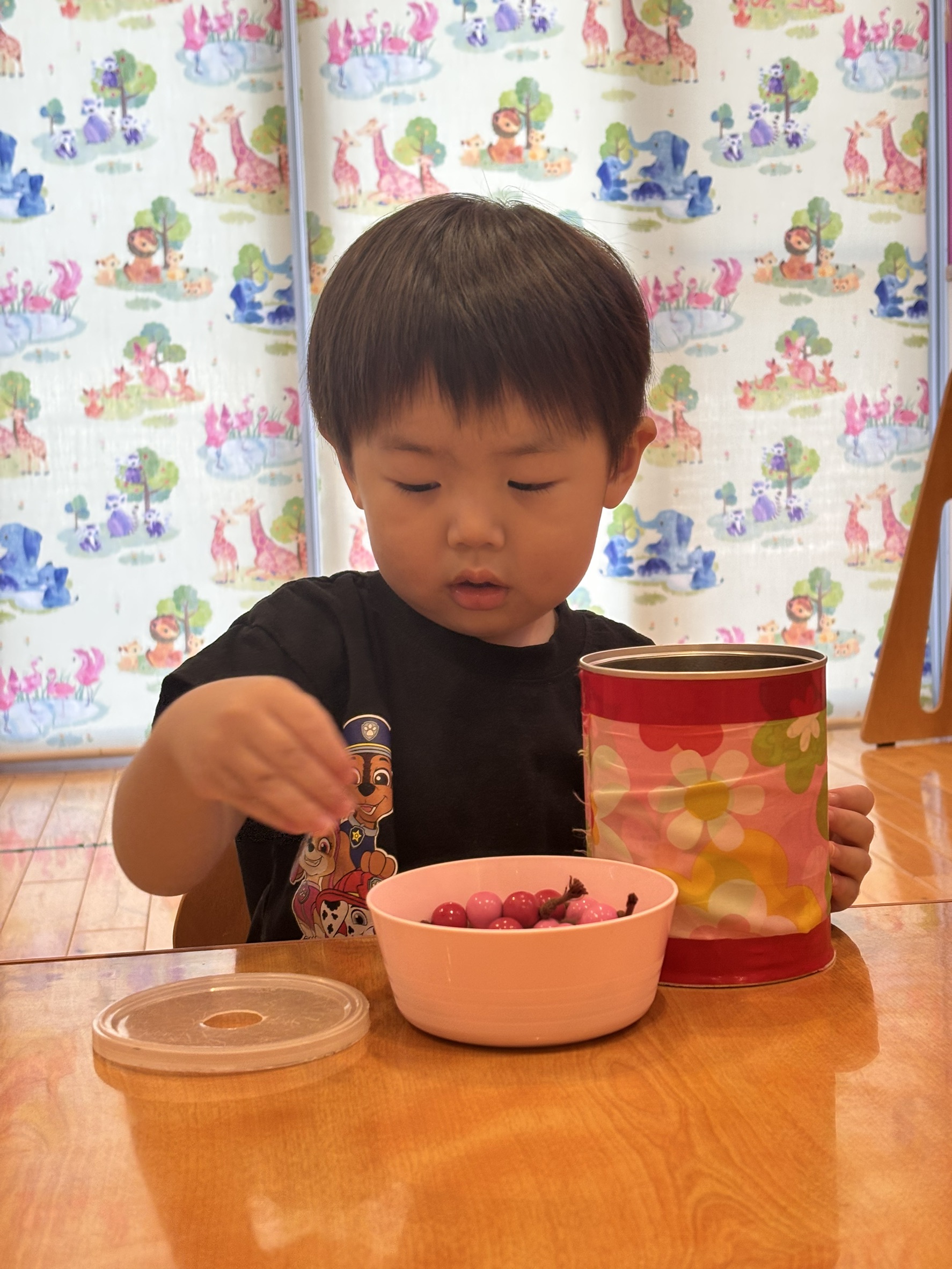 小さな素材を器から缶へ移す様子