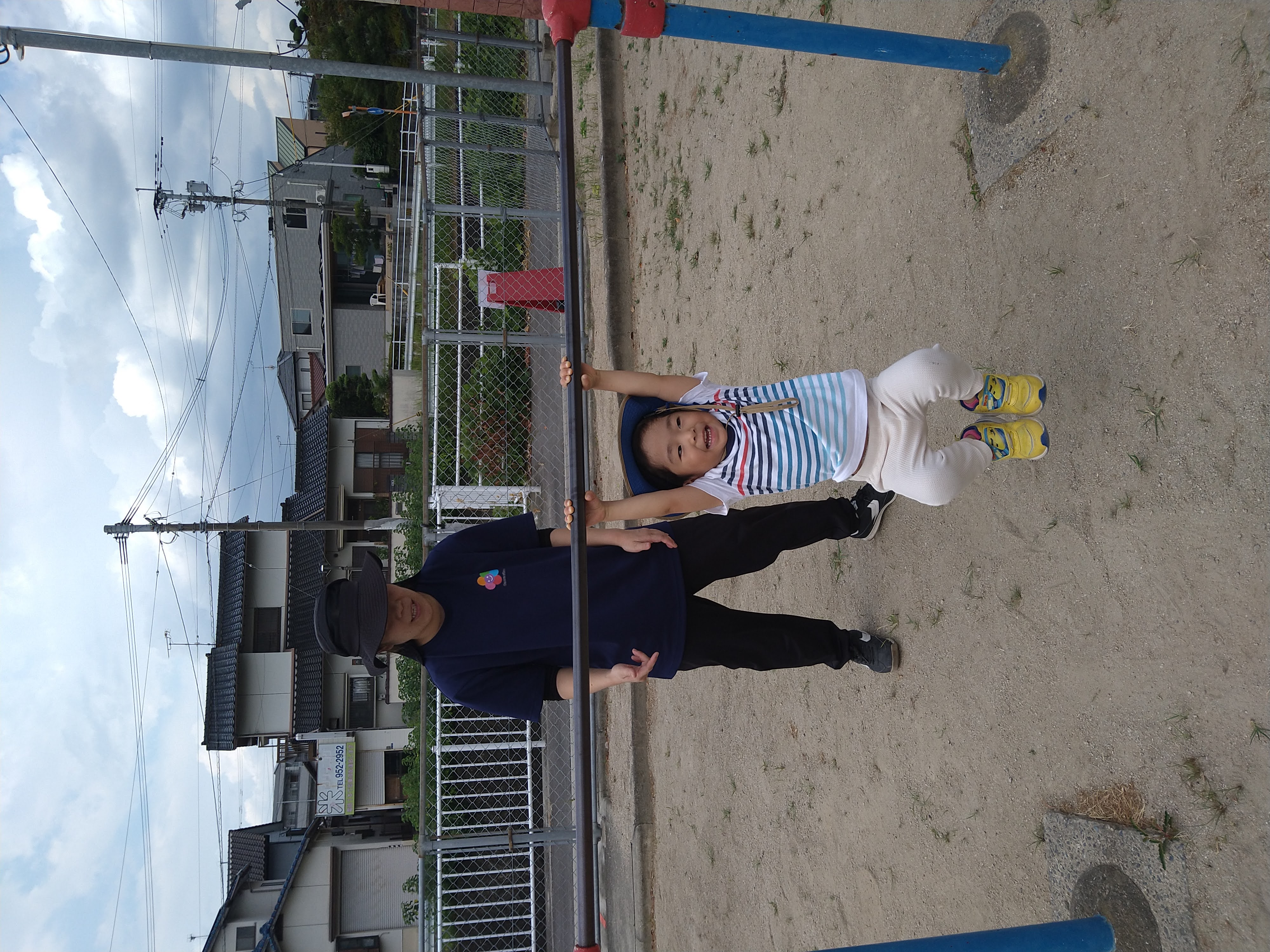 鉄棒にぶら下がり笑顔を見せる子ども