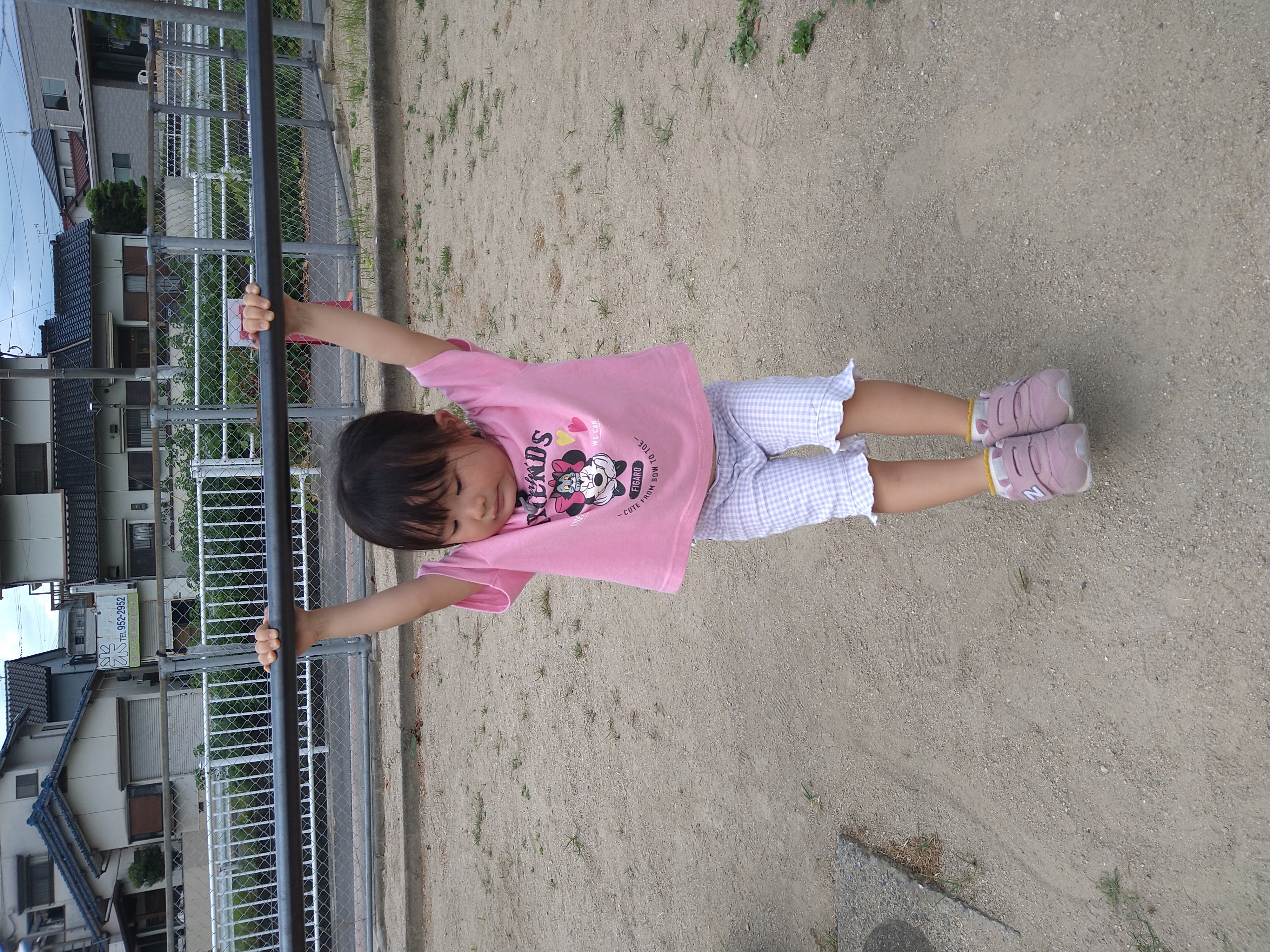 両手を伸ばして鉄棒にぶら下がる子ども