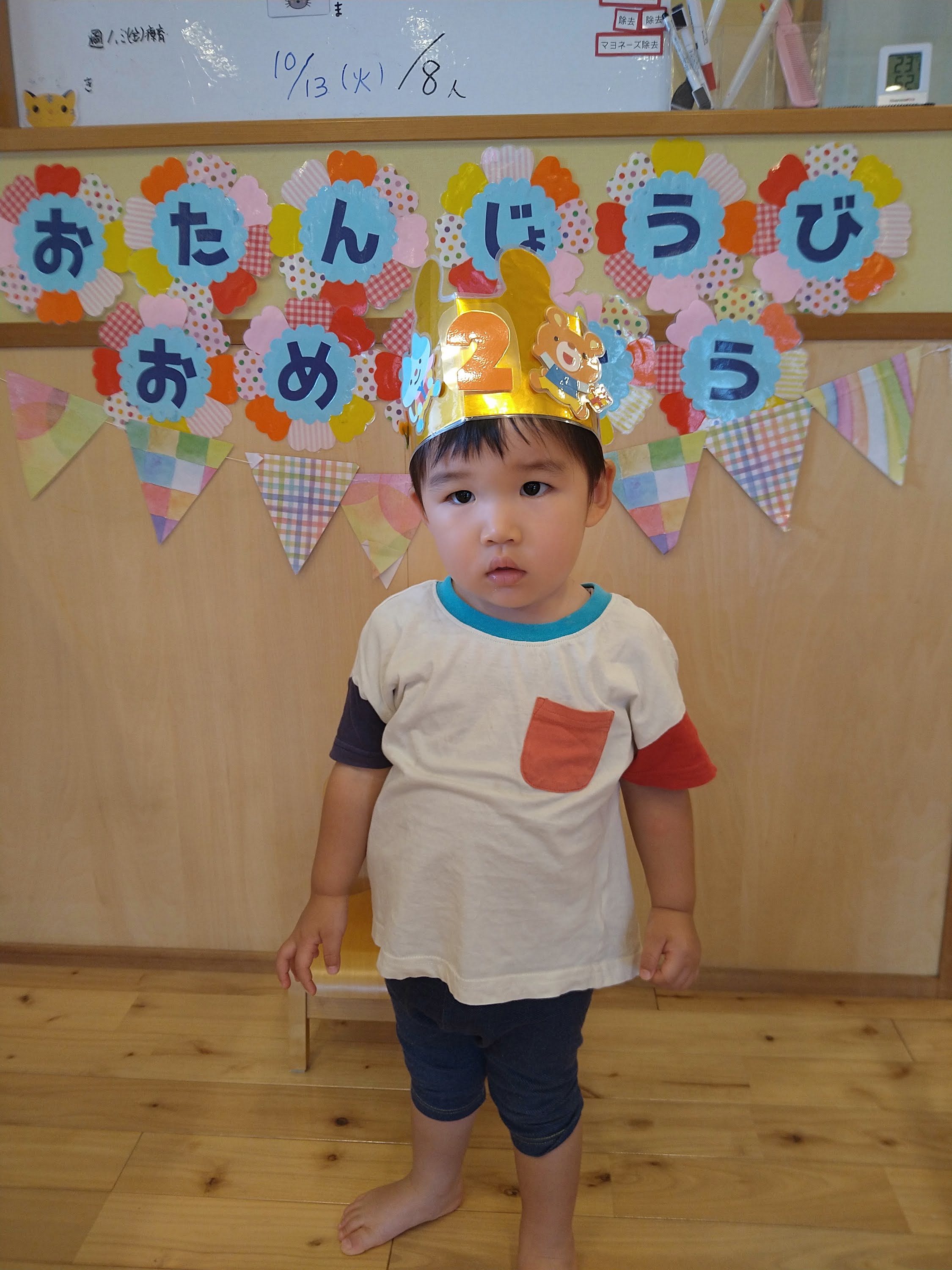 お誕生日会でマイクを持ち指を広げて伝える子ども