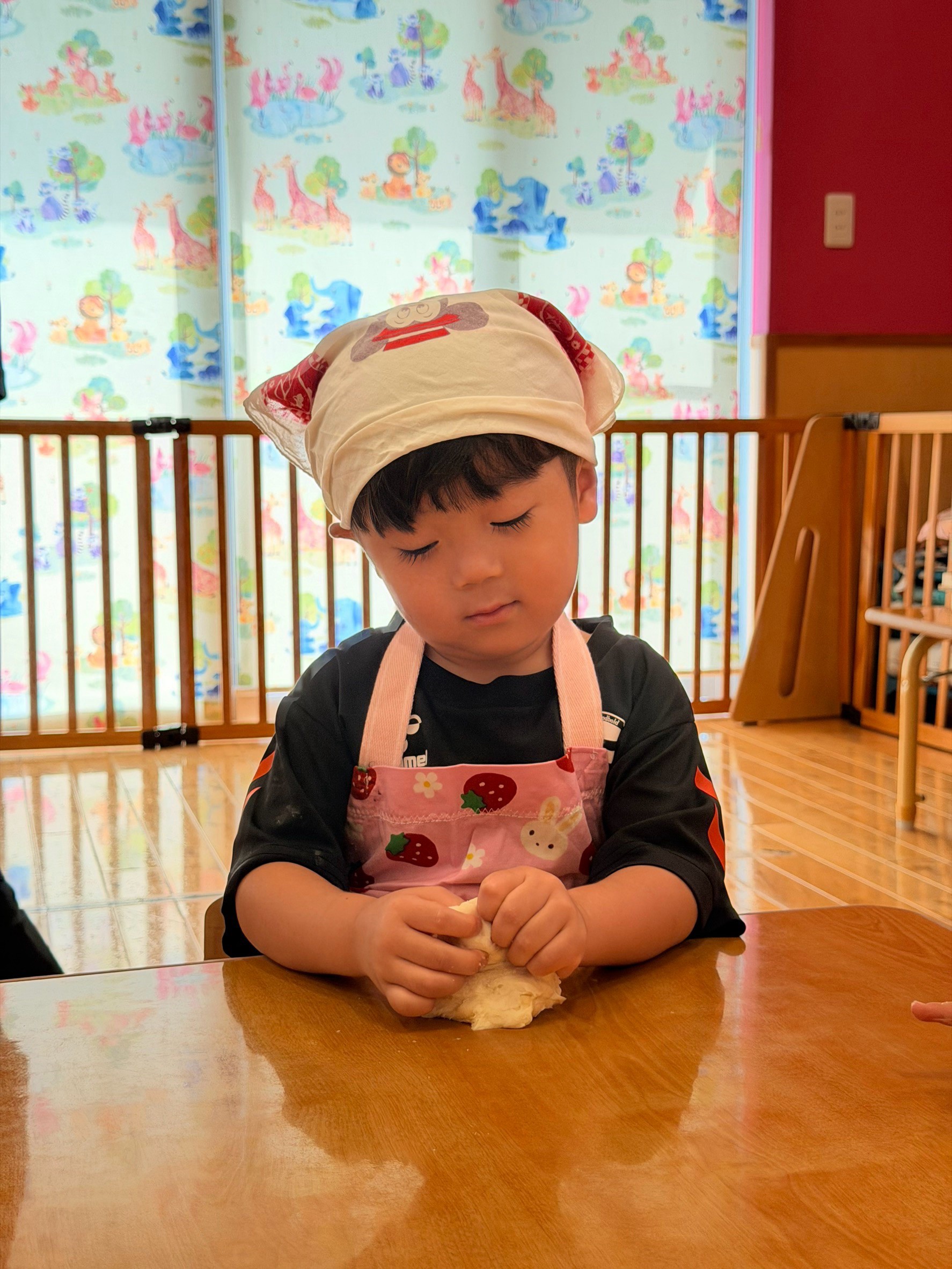 お月見会で白い生地を両手でこねる子ども