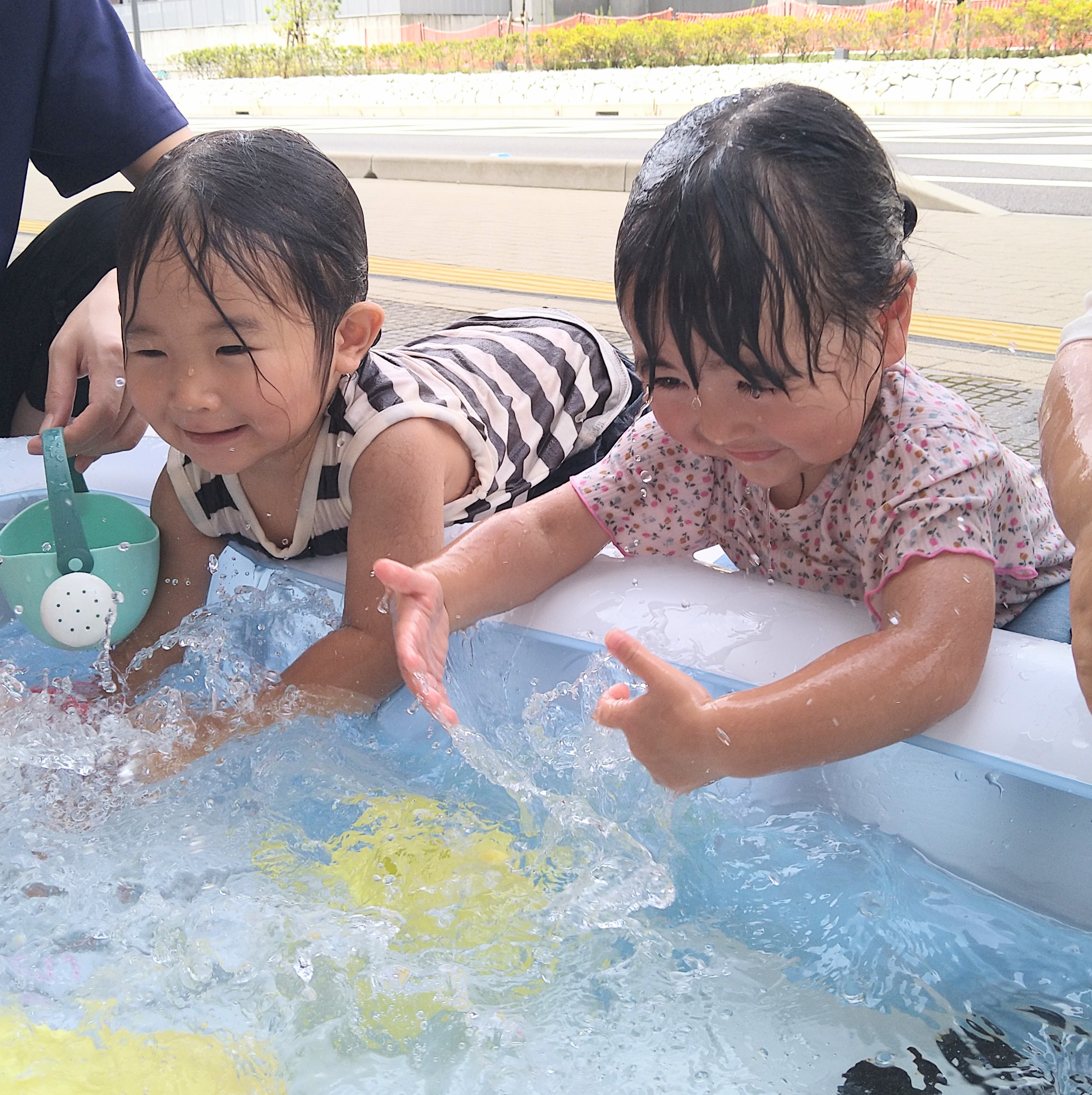 たらいの水を手のひらで動かし、水しぶきを楽しむ様子