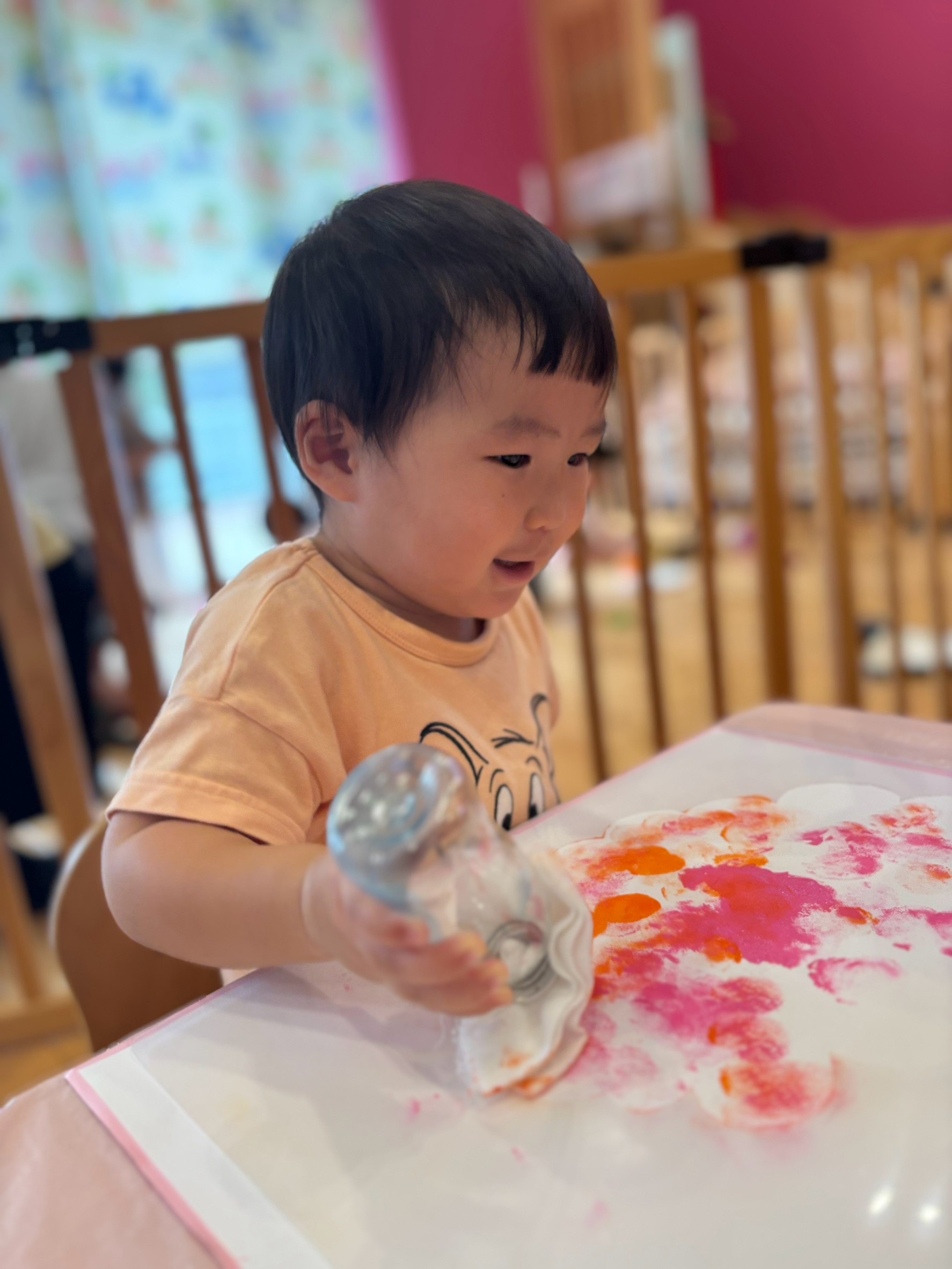 敬老の日の贈り物へ道具で赤や桃色の模様をつける子ども