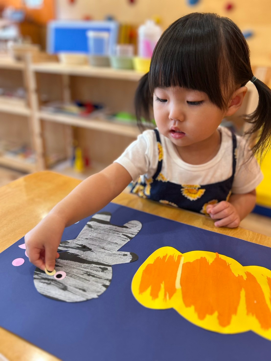 ミイラの目の位置を確かめながら貼る子ども