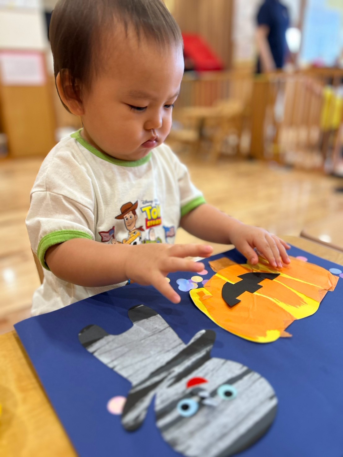 かぼちゃとミイラの飾りに手を伸ばす子ども