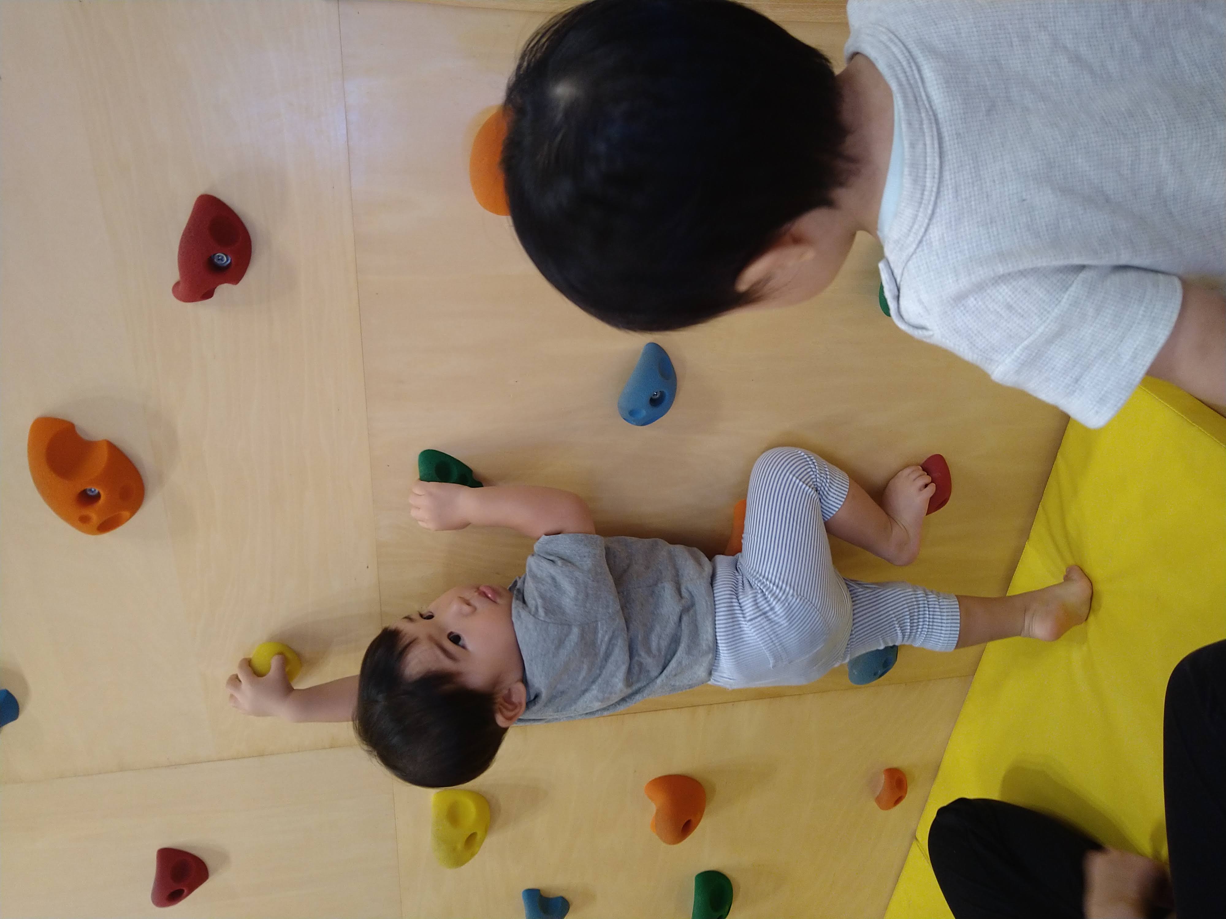 左右の手でホールドをつかみ次の足場を探す子ども