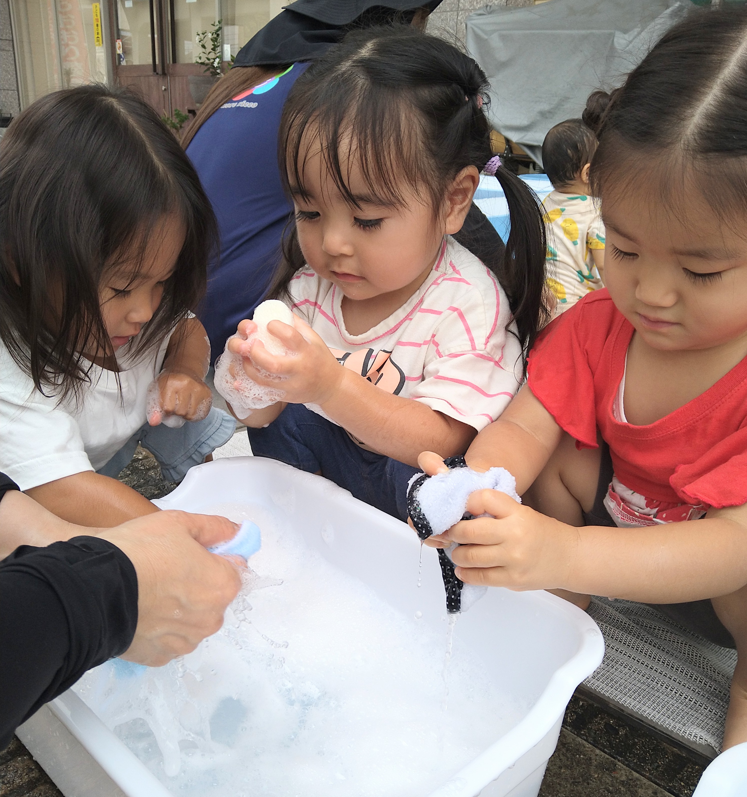 泡水に浸した布を手で握って感触を確かめる子どもたち