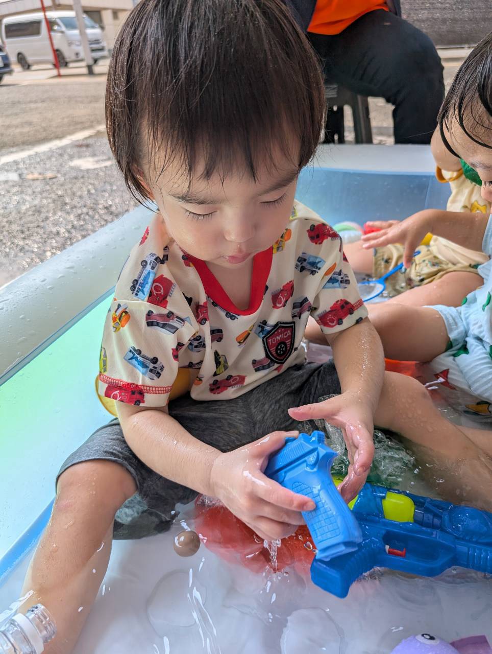水鉄砲を手に持ち水の動きを楽しむ子どもたち