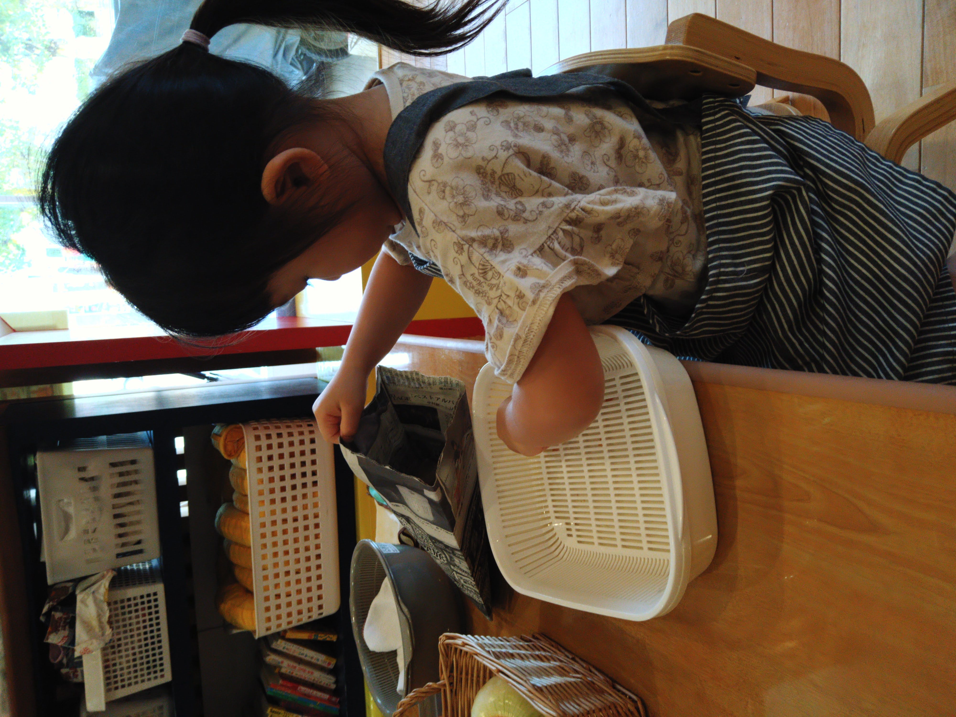 むいた玉ねぎの皮をかごに分ける子ども