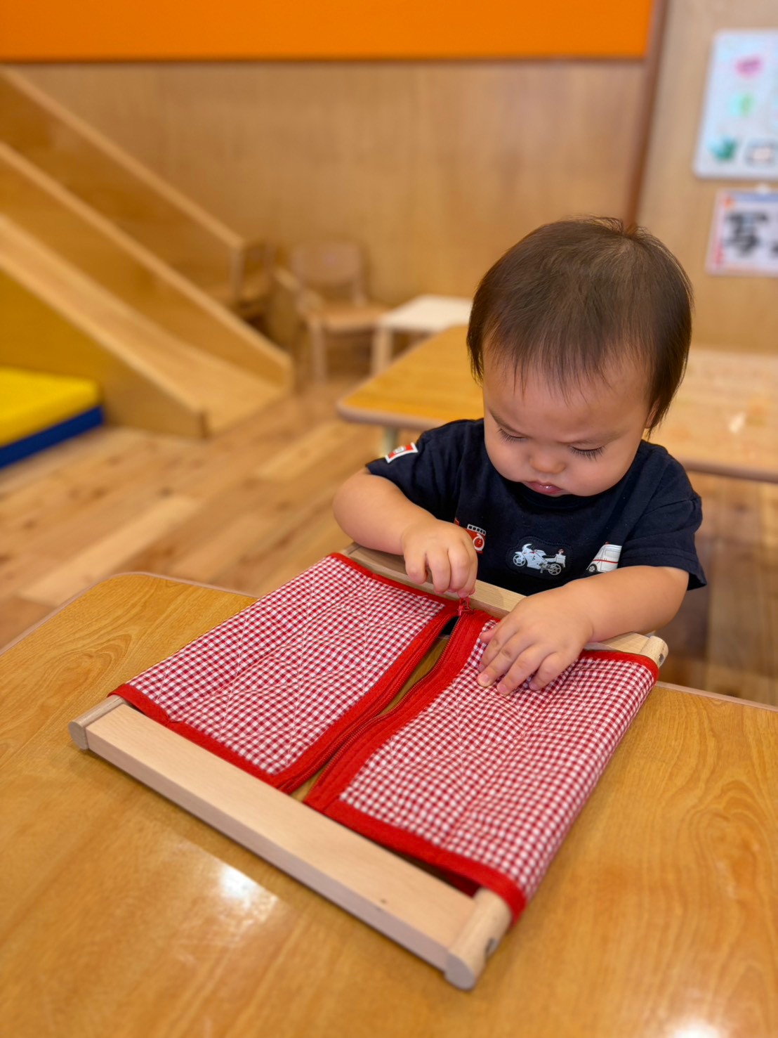 着衣枠の金具を指先でつまむ子ども