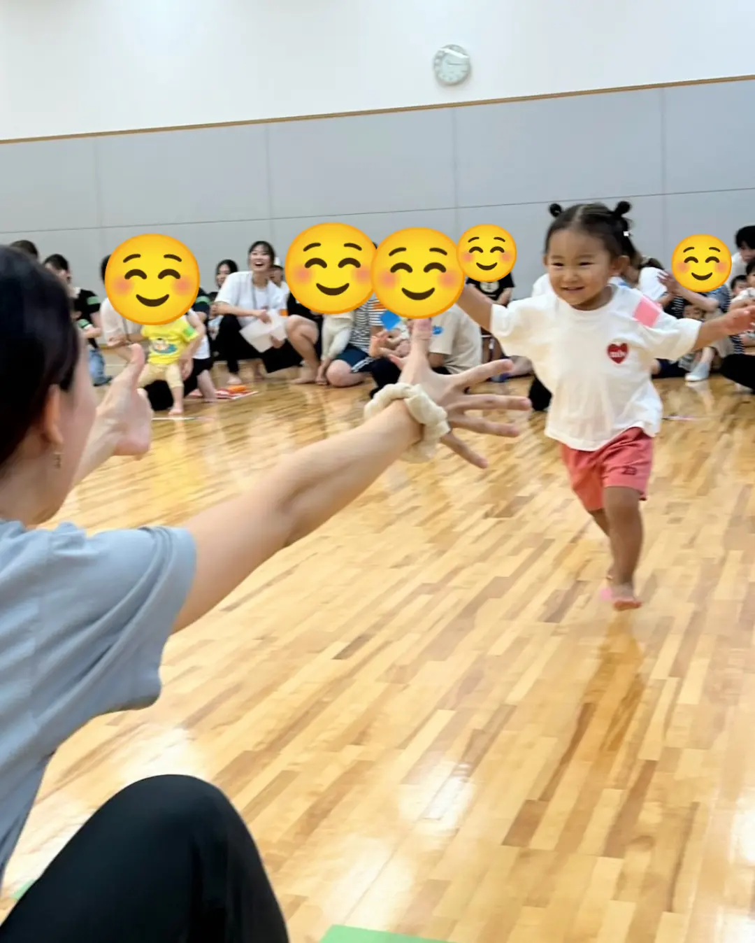 腕を広げて待つ保護者を目指して走る子ども