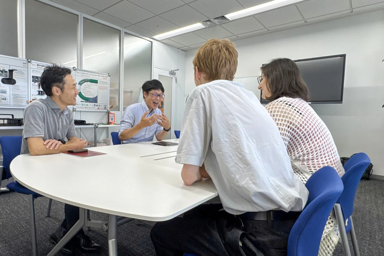 会議室のテーブルを囲んで話し合う皆様