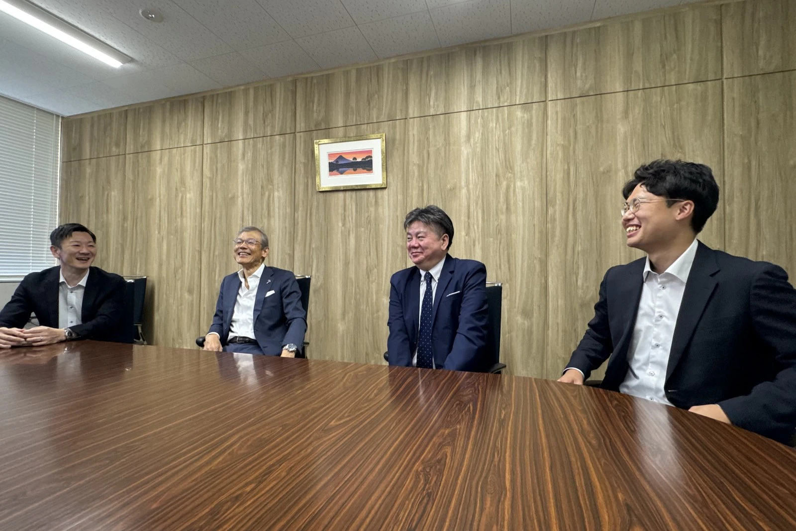 会議室で談笑しながら取材に応じる4名の方々