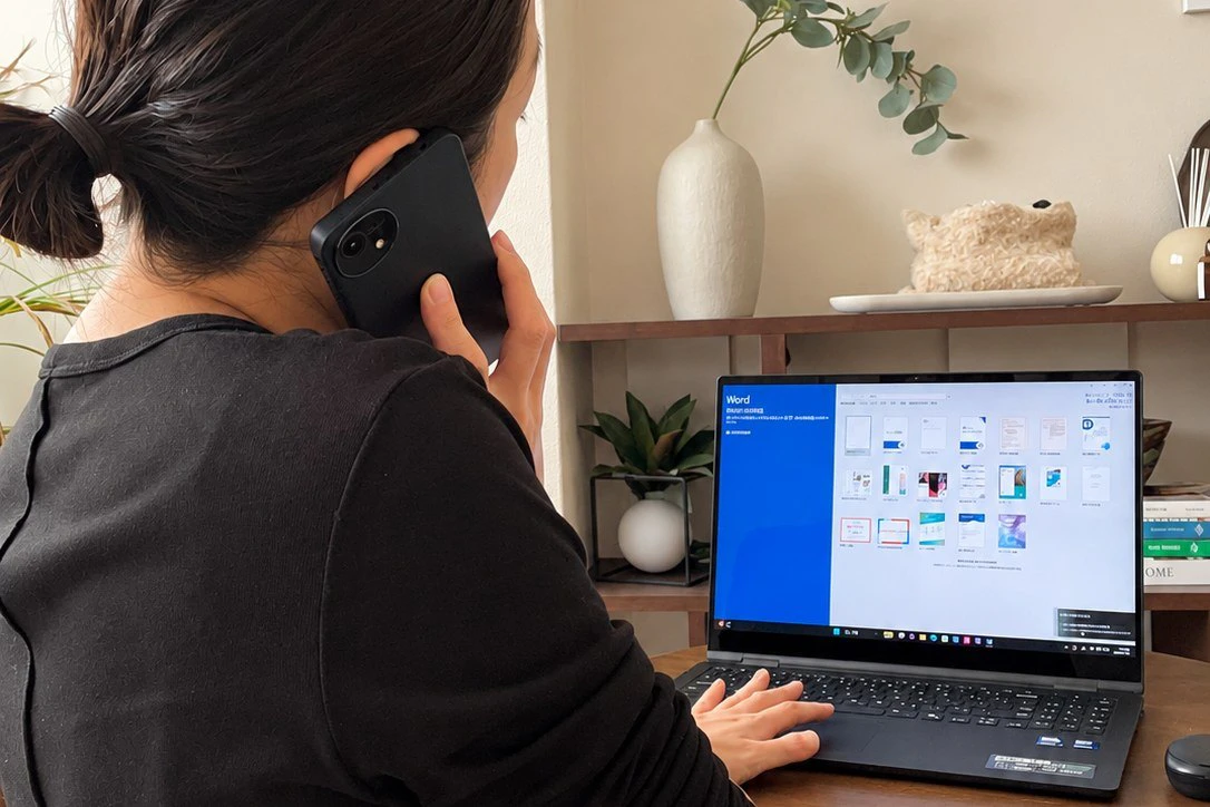 フロンティアマーケティング株式会社の業務中のイメージ。電話をしながらノートパソコンで作業している