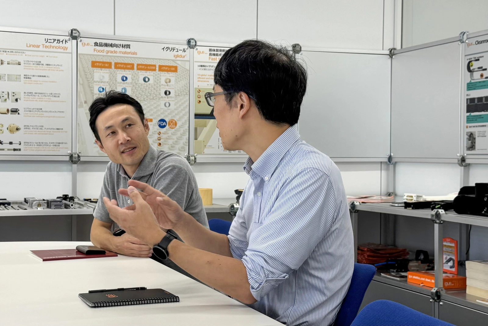 会議室で向かい合って話す社員のお二人