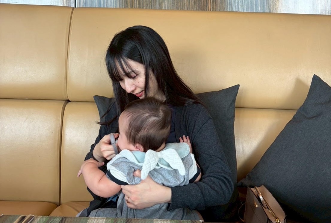 ソファでお子さんを優しく抱っこする伊藤さん