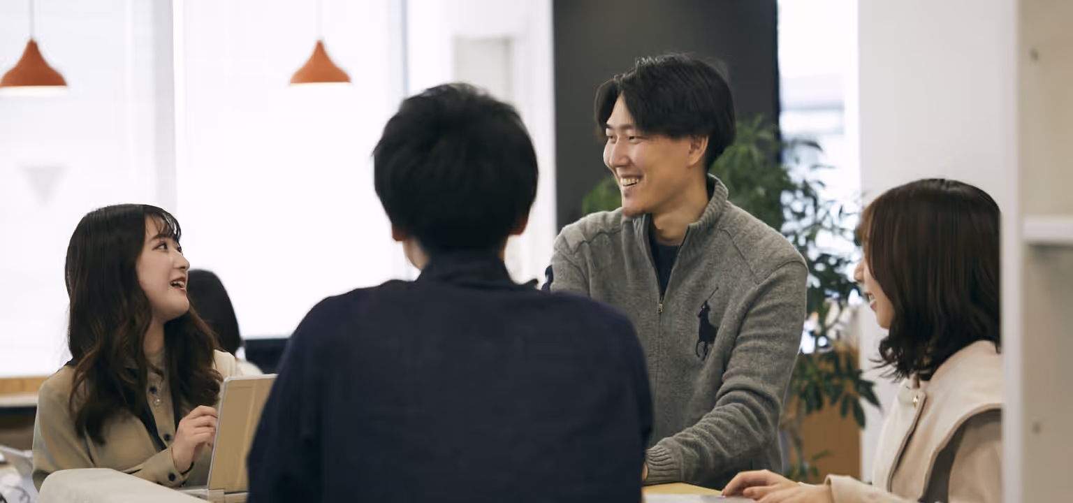 インターグの４人のメンバーがオフィスで談笑している様子。