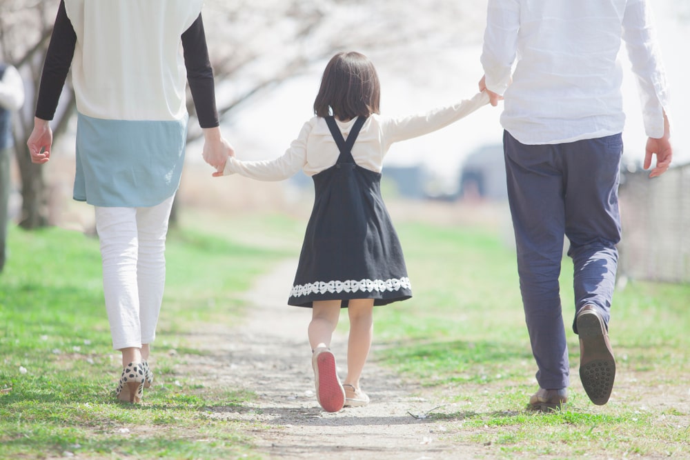 手をつないで歩く親子
