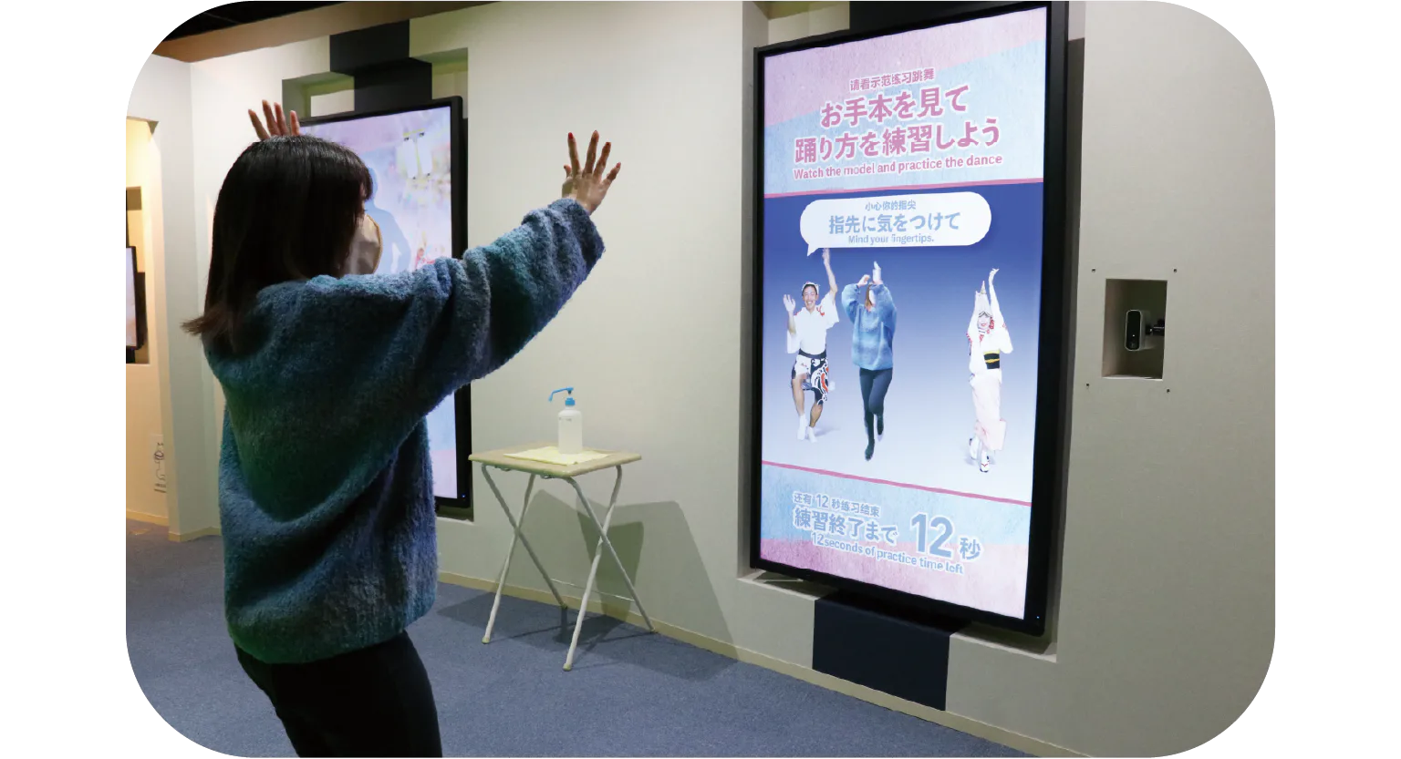 モニターに合わせて踊る女性の画像