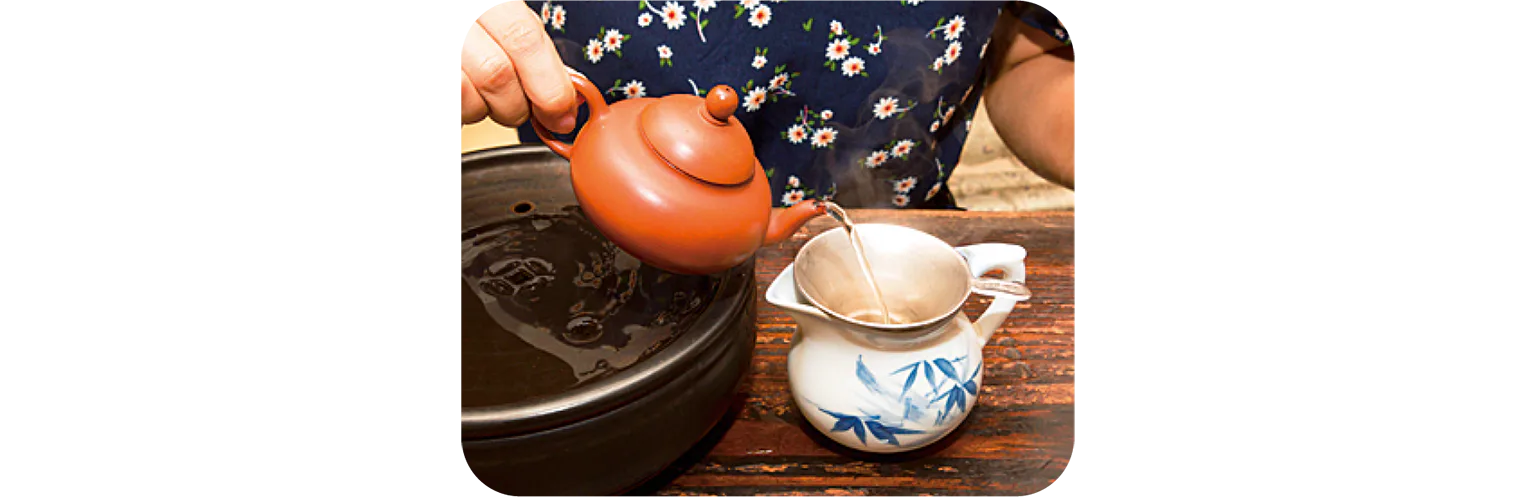 茶壺から茶海にお茶を注ぐ画像