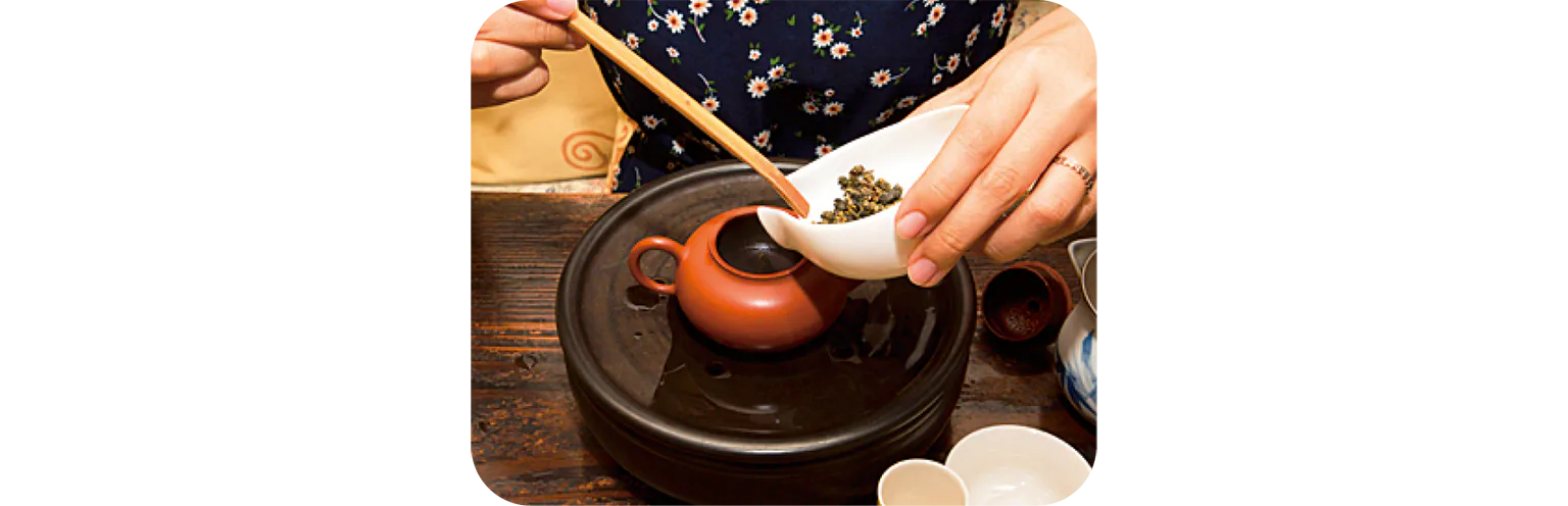 茶壺に茶葉を入れる画像
