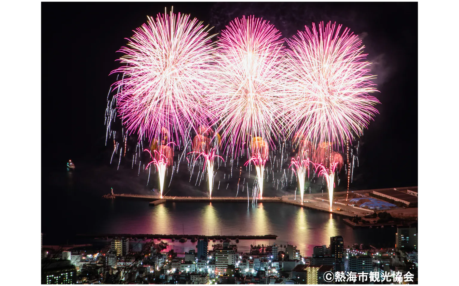 防潮堤から花火が打ち上がる画像