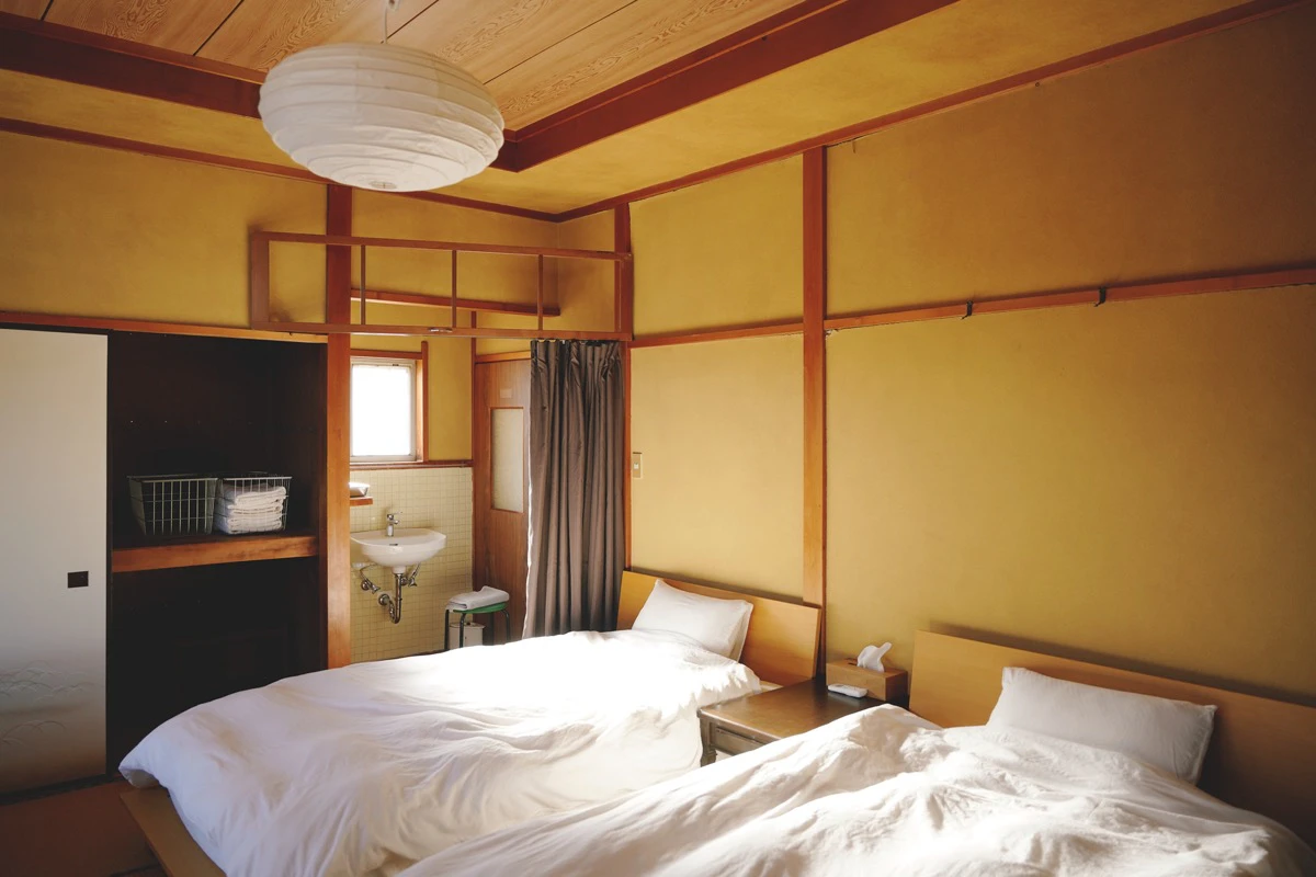 2部屋に区切られたリビングルームの奥にはベッドルームも。布団を敷いて寝ることができるので、大人数でも宿泊可能です（ベッド2台、床用マットレス8台）。