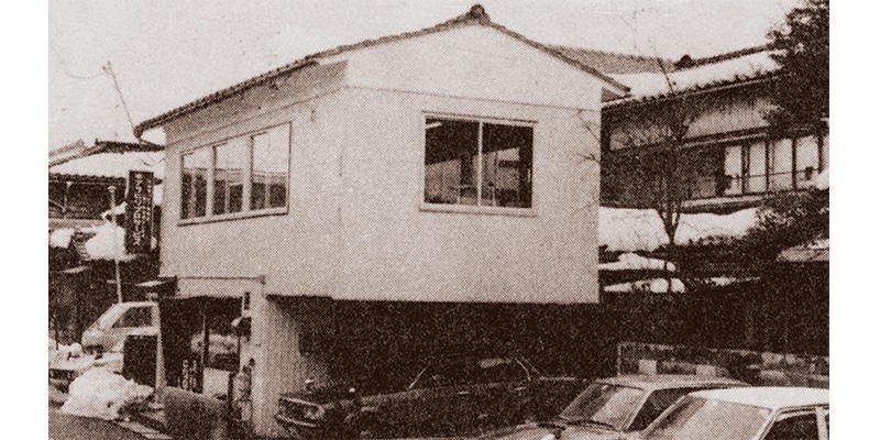 創業時は新潟市中央区関屋田町の空き家を事務所とした（奥の2階建てを含む）。