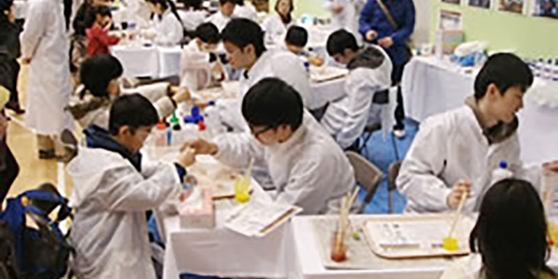 「科学の祭典」の様子。紫外線で液体を固める実験などを行う子どもたち。
