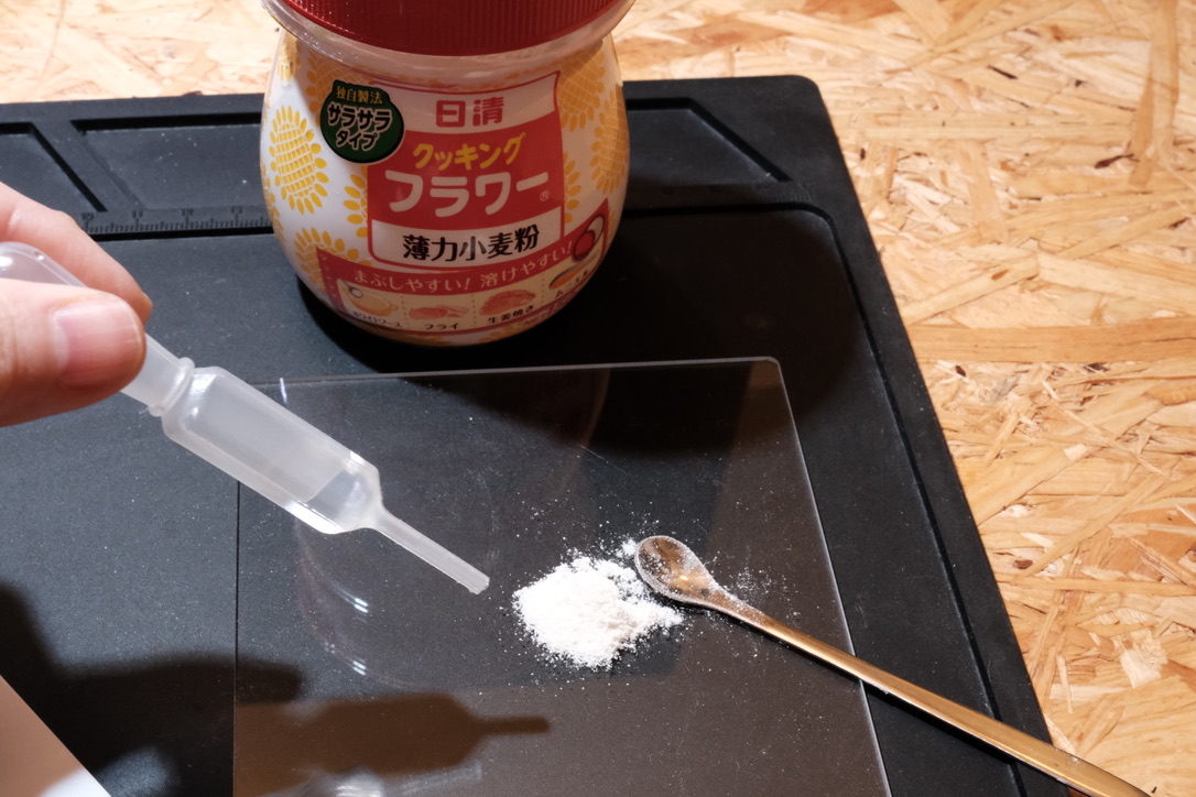写真:小麦粉にスポイトで水を加えている