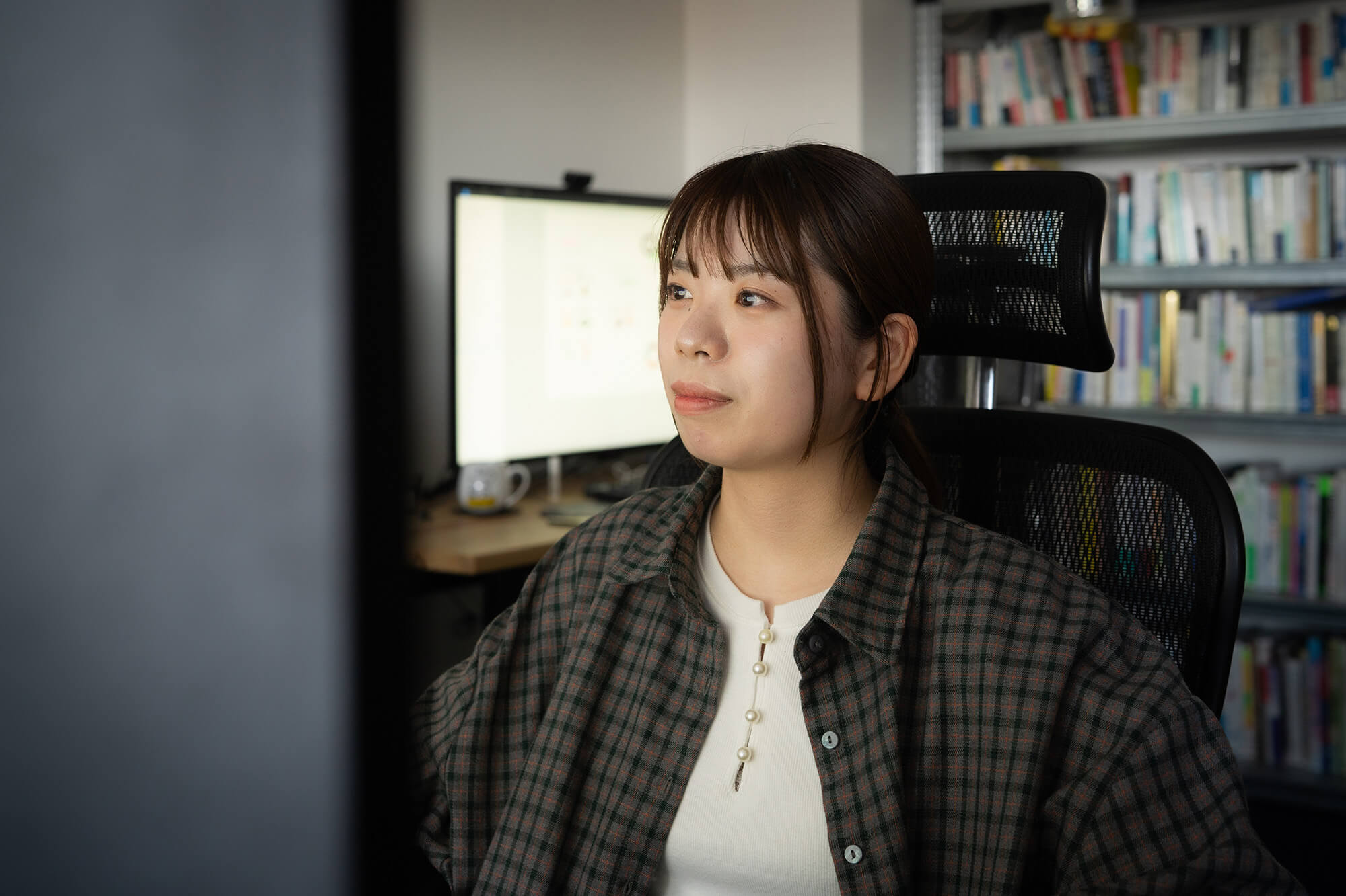 安達友香さんがPCに向かって作業している写真