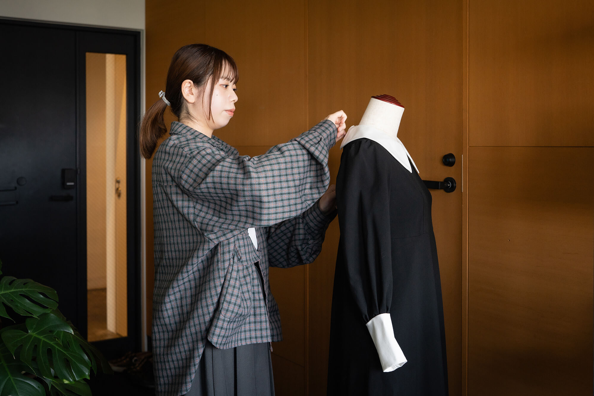 安達友香さんがワンピースの襟を直している写真
