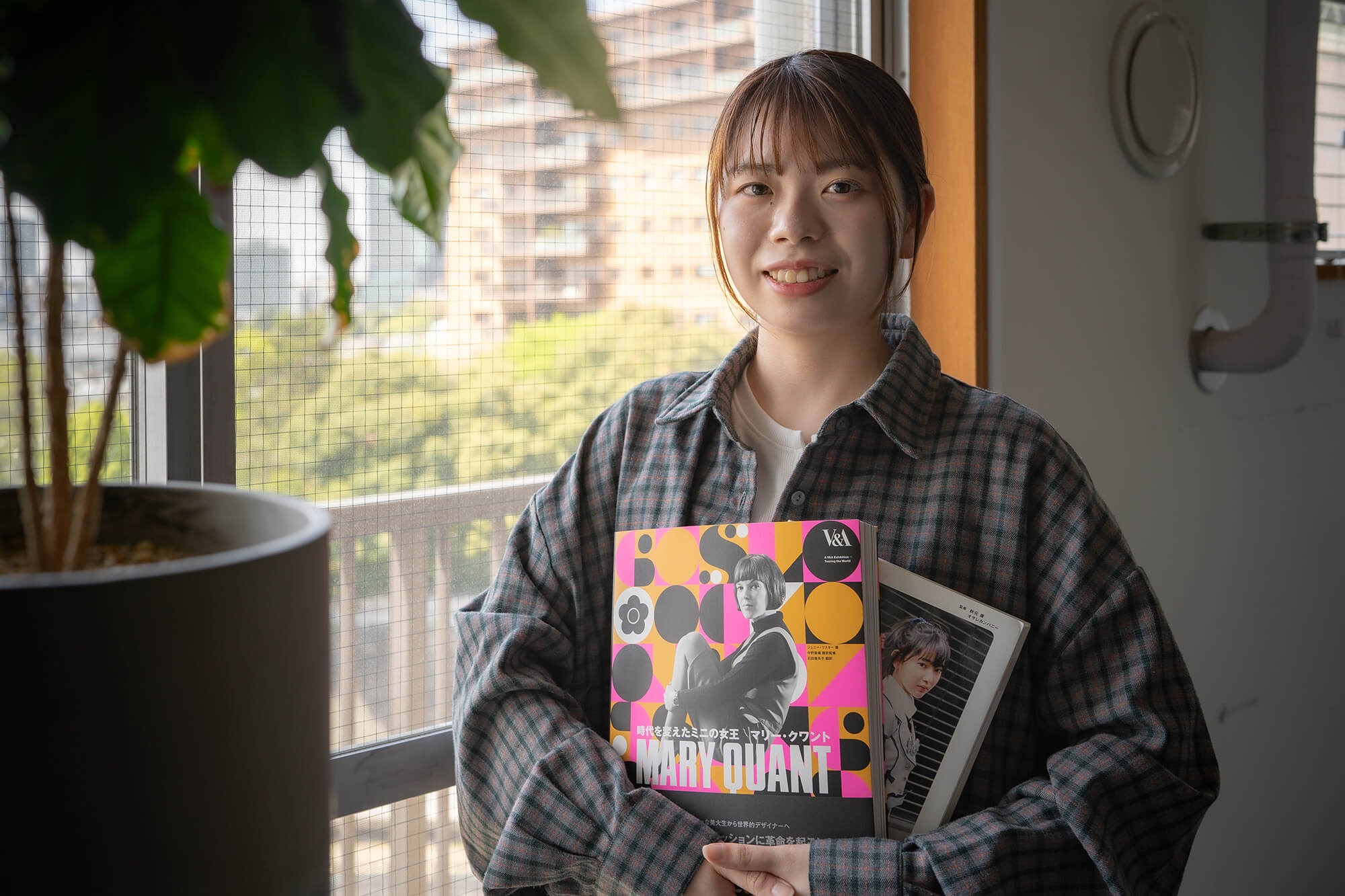 安達友香さんが本を持っている写真