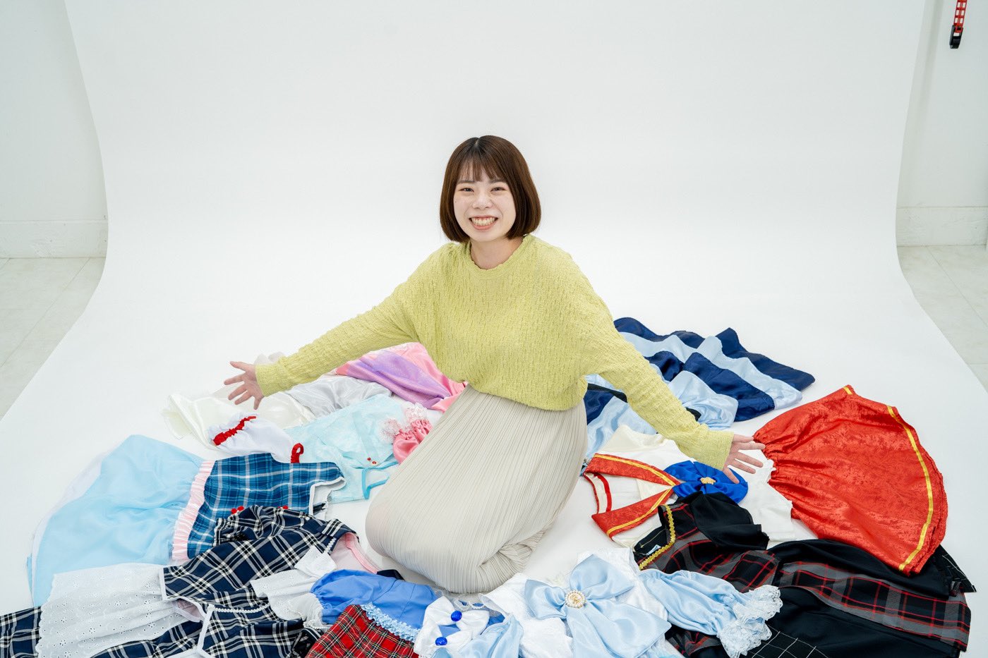 安達友香さんプロフィール写真。衣装の中央で手を広げている画像。