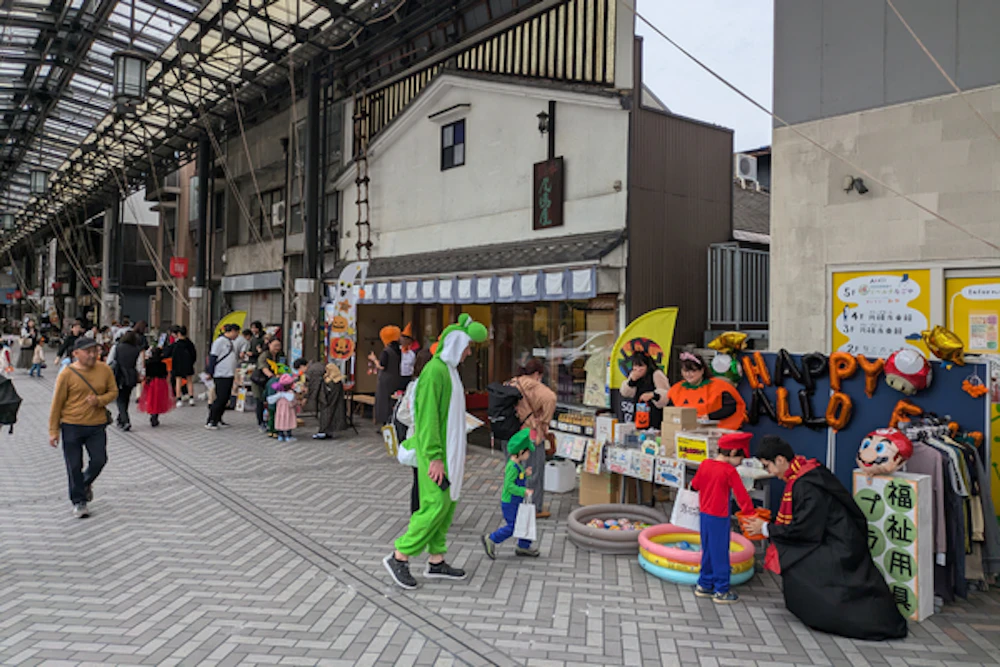 仮装した親子が店先で「トリック・オア・トリート」をしている様子。