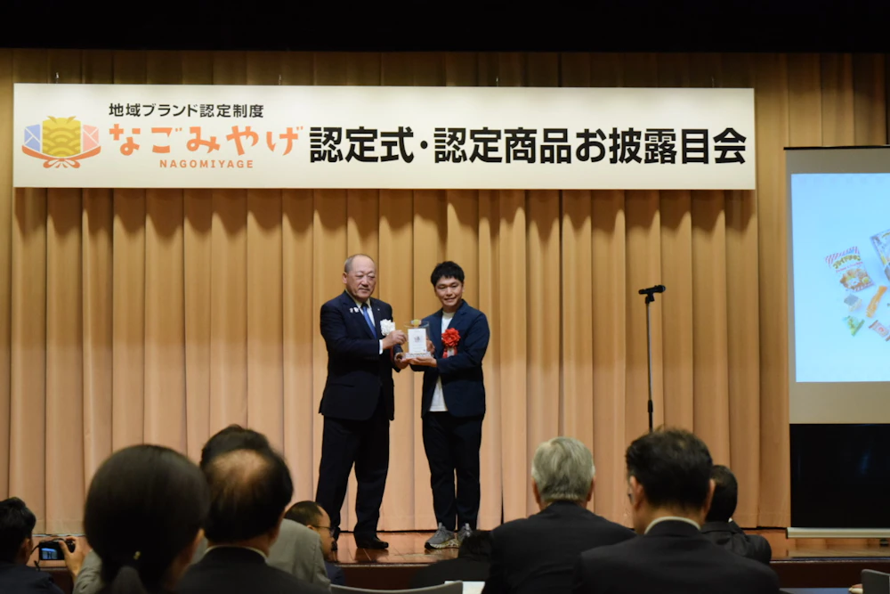 会頭から認定証を受け取る様子。