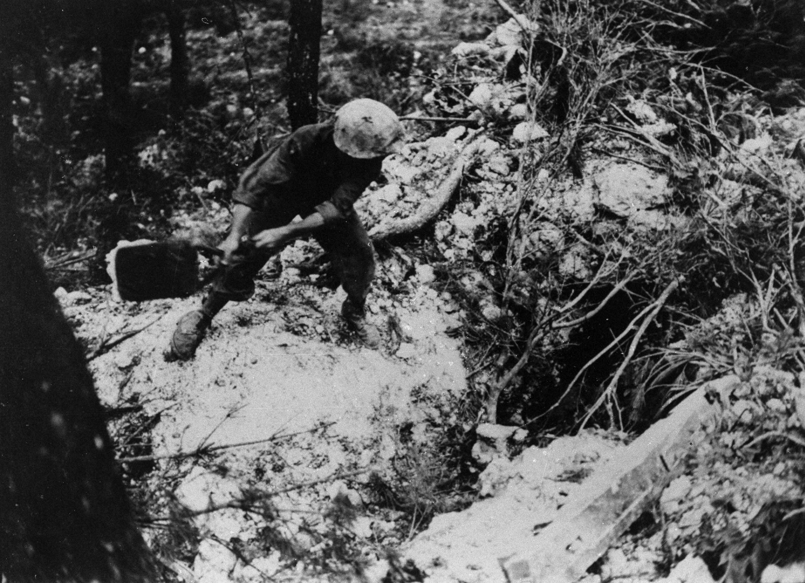 日本軍陣地の洞穴に火のついた石油缶を投げ込む米兵