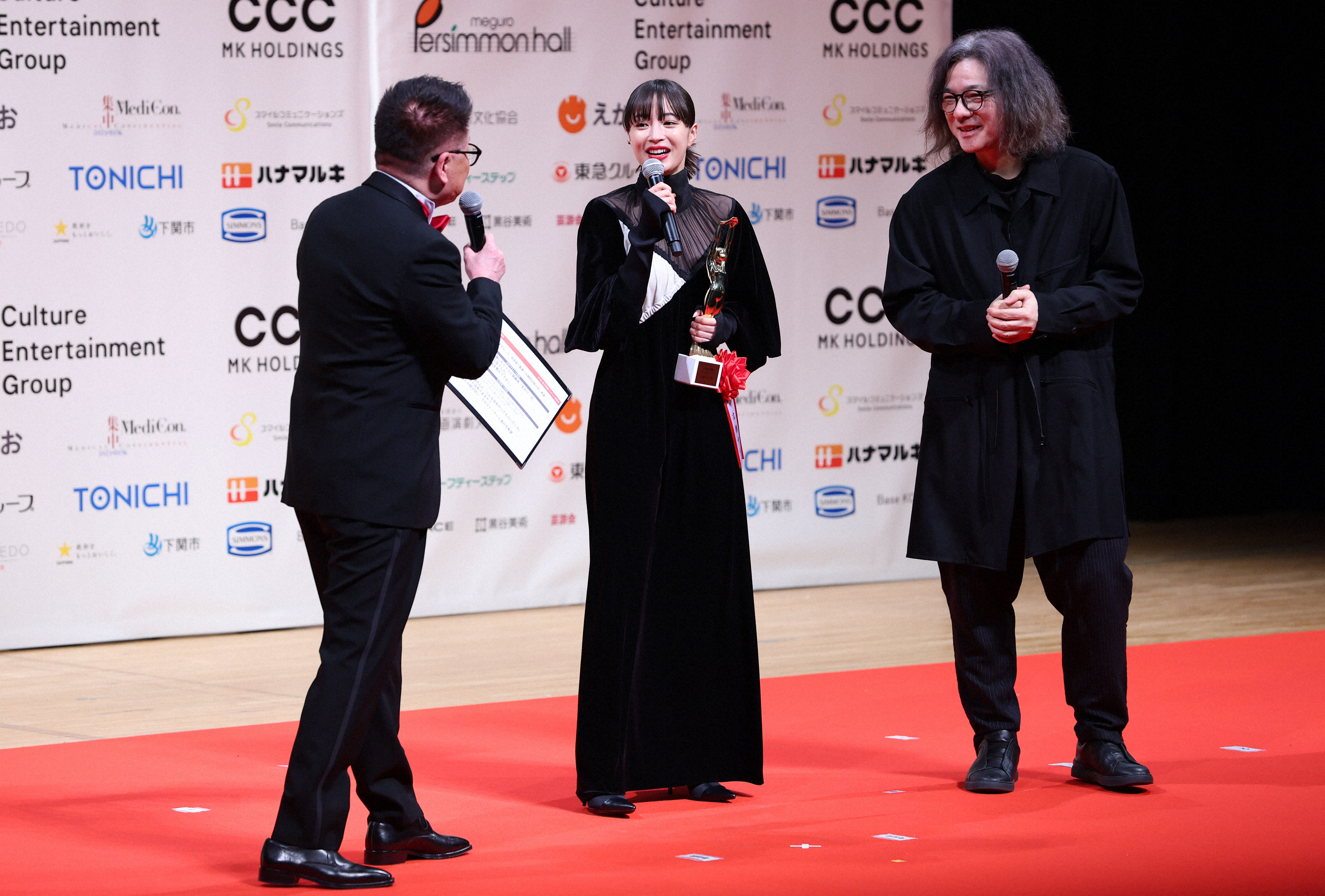 第78回毎日映コン・女優助演賞を受賞し、岩井俊二監督（右）と壇上に立つ広瀬すず（中央）